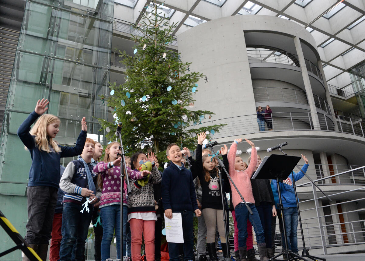  Bundestagsvizepräsident Thomas Oppermann, SPD, nimmt im Namen des Deutschen Bundestages in der Halle des Paul-Löbe-Hauses vor der westseitigen Fensterfront einen Weihnachtsbaum des Naturparks Schwalm-Nette entgegen. Kinder der Grundschule Lobberich (hier im Bild) tragen Weihnachtslieder vor.; Übersicht, Weihnacht, Weihnachten, Baum.