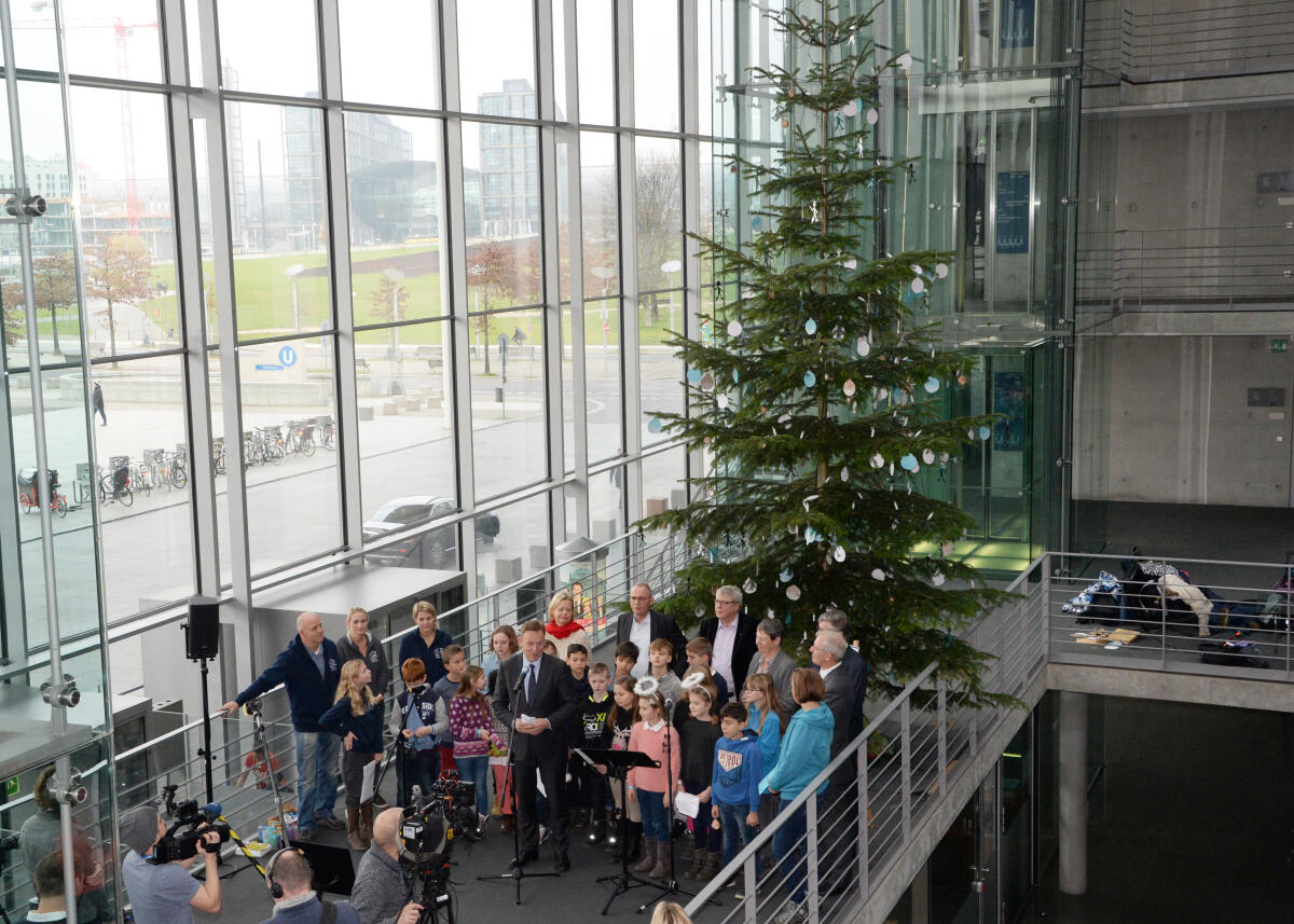Oppermann, Thomas Bundestagsvizepräsident Thomas Oppermann, (am Mikrofon), SPD, nimmt im Namen des Deutschen Bundestages in der Halle des Paul-Löbe-Hauses vor der westseitigen Fensterfront einen Weihnachtsbaum des Naturparks Schwalm-Nette entgegen. Kinder der Grundschule Lobberich tragen Weihnachtslieder vor.; Übersicht, Weihnacht, Weihnachten, Baum.