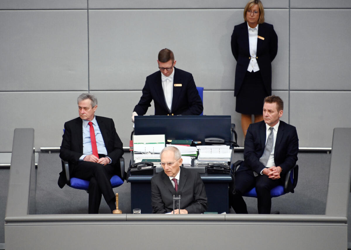 Schäuble, Wolfgang Die 154. Sitzung des Deutschen Bundestages findet auf Grundlage der Corona-Krise mit zahlreichen Veränderungen statt. Dazu gehört vorwiegend: Abstand zueinander halten. Die Stuhlreihen im Plenum sind mit dem Hinweis versehen "Bitte frei lassen", sodass die Bundestagsabgeordneten während der Debatten und Tagesordnungspunkten nicht direkt nebeneinander sitzen. Desweiteren gibt es Hinweise zu Verhaltensmustern. Bundestagspräsident Dr. Wolfgang Schäuble (am Vorsitz), CDU/CSU, sitzt ohne Schriftführer am Vorsitz. Diese haben neben den Stenographenplätzen, von denen jeweils nur einer stenographiert, Platz genommen.