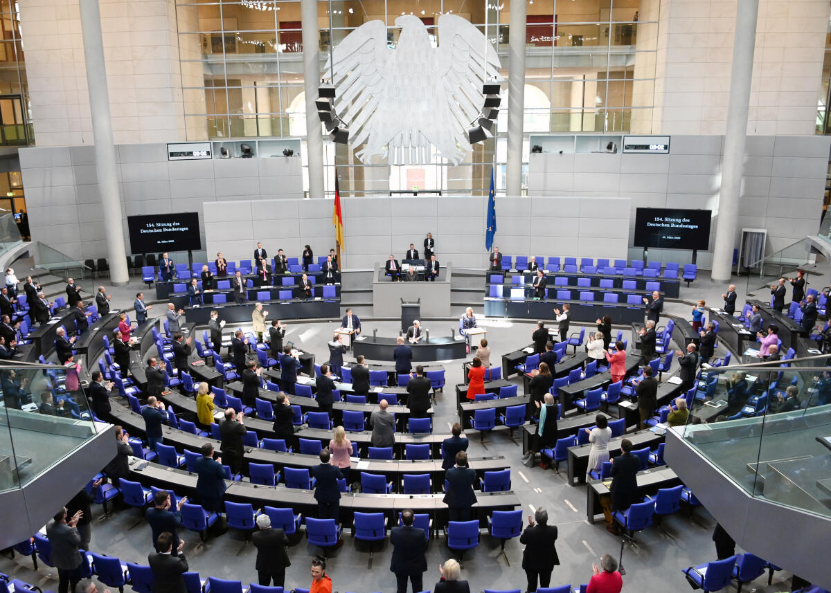  Die 154. Sitzung des Deutschen Bundestages findet auf Grundlage der Corona-Krise mit zahlreichen Veränderungen statt. Dazu gehört vorwiegend: Abstand zueinander halten. Die Stuhlreihen im Plenum sind mit dem Hinweis versehen "Bitte frei lassen", sodass die Bundestagsabgeordneten während der Debatten und Tagesordnungspunkte nicht direkt nebeneinander sitzen. Desweiteren gibt es Hinweise zu Verhaltensmustern. Bundestagspräsident Dr. Wolfgang Schäuble, CDU/CSU, sitzt ohne Schriftführer am Vorsitz. Diese haben neben den Stenografenplätzen, von denen jeweils nur einer stenographiert, Platz genommen. Hier erheben sich die Bundestagsabgeordneten von ihren Plätzen und applaudieren für diejenigen, die vom Bundestagspräsidenten für ihre Leistungen, die Versorgung am Leben zu halten, und den Ärzten und Pflegekräften, dankbar erwähnt werden.; Übersicht.