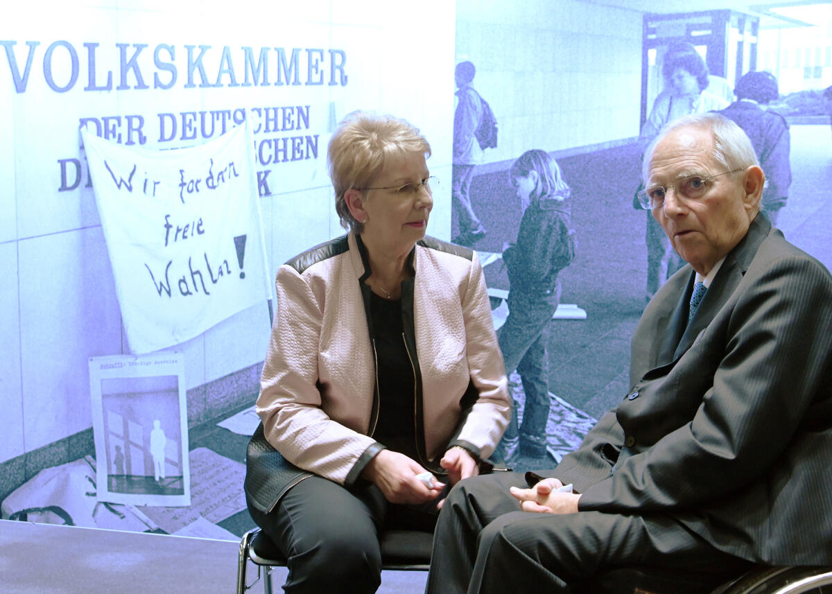 Bundestagspräsident Dr. Wolfgang Schäuble, (hier im Bild), CDU/CSU, eröffnet im Beisein der ehemaligen Präsidentin der Volkskammer der DDR, Dr. Sabine Bergmann-Pohl, (hier im Bild), aus Anlass des 30. Jahrestages der einzigen freien Volkskammerwahl in der DDR, in der Halle des Paul-Löbe-Hauses des Deutschen Bundestages eine Ausstellung. Ines Arland führt ein Gespräch mit dem ehemaligen Korrespondenten der österreichischen Tageszeitung "Die Presse", Ewald König, der zu dieser Zeit viele Termine zu den Ereignissen vor 30 Jahren wahrgenommen hat. Musikalisch wird die Ausstellungseröffnung vom Blechbläserquintett des Deutschen Symphonie-Orchesters Berlin begleitet. Unter den Besuchern sind viele, die die damaligen geschichtlichen Abläufe mit erlebt haben, u.a. Lothar de Maizière. Schäuble, Wolfgang; Bergmann-Pohl, Sabine Bundestagspräsident Dr. Wolfgang Schäuble, (hier im Bild), CDU/CSU, eröffnet im Beisein der ehemaligen Präsidentin der Volkskammer der DDR, Dr. Sabine Bergmann-Pohl, (hier im Bild), aus Anlass des 30. Jahrestages der einzigen freien Volkskammerwahl in der DDR, in der Halle des Paul-Löbe-Hauses des Deutschen Bundestages eine Ausstellung. Ines Arland führt ein Gespräch mit dem ehemaligen Korrespondenten der österreichischen Tageszeitung "Die Presse", Ewald König, der zu dieser Zeit viele Termine zu den Ereignissen vor 30 Jahren wahrgenommen hat. Musikalisch wird die Ausstellungseröffnung vom Blechbläserquintett des Deutschen Symphonie-Orchesters Berlin begleitet. Unter den Besuchern sind viele, die die damaligen geschichtlichen Abläufe mit erlebt haben, u.a. Lothar de Maizière.