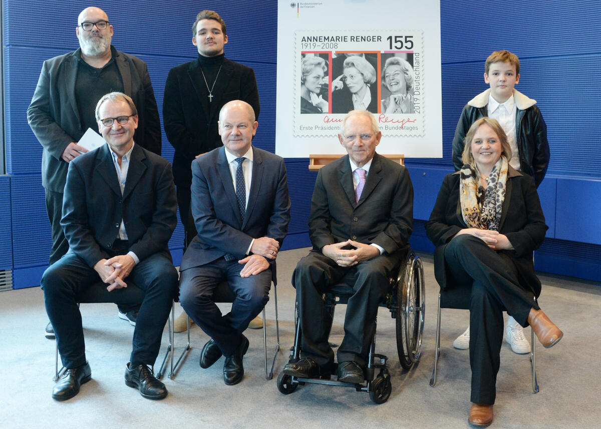 Schäuble, Wolfgang; Scholz, Olaf; Schick, Claudia; Renger, Reinhard; Schick, Alexander; Schick, Patrick Glen; Schick, David Miles Bundestagspräsident Dr. Wolfgang Schäuble, (2.v.re), CDU/CSU, nimmt von Bundesminister Olaf Scholz, (sitzend 2.v.li), SPD,  ein Sonderpostwertzeichen aus Anlass des 100. Geburtstages von Annemarie Renger, der ersten (1.) Präsidentin (1972 bis 1976) des Deutschen Bundestages, entgegen. Renger gehörte von 1953 bis 1990 dem Bundestag an. An der Übergabe der Sonderbriefmarke, die von Julia Neller entworfen wurde, waren Familienangehörige Rengers zugegen. Die Enkelin Claudia Schick, (sitzend re), der Enkel Reinhard Renger, (sitzend li), der Ehemann der Enkelin, Alexander Schick, (stehend li), und die Urenkel Patrick Glen Schick (stehend 2.v.li) und David Miles Schick (stehend re).; Briefmarke, Geste, Gestik.