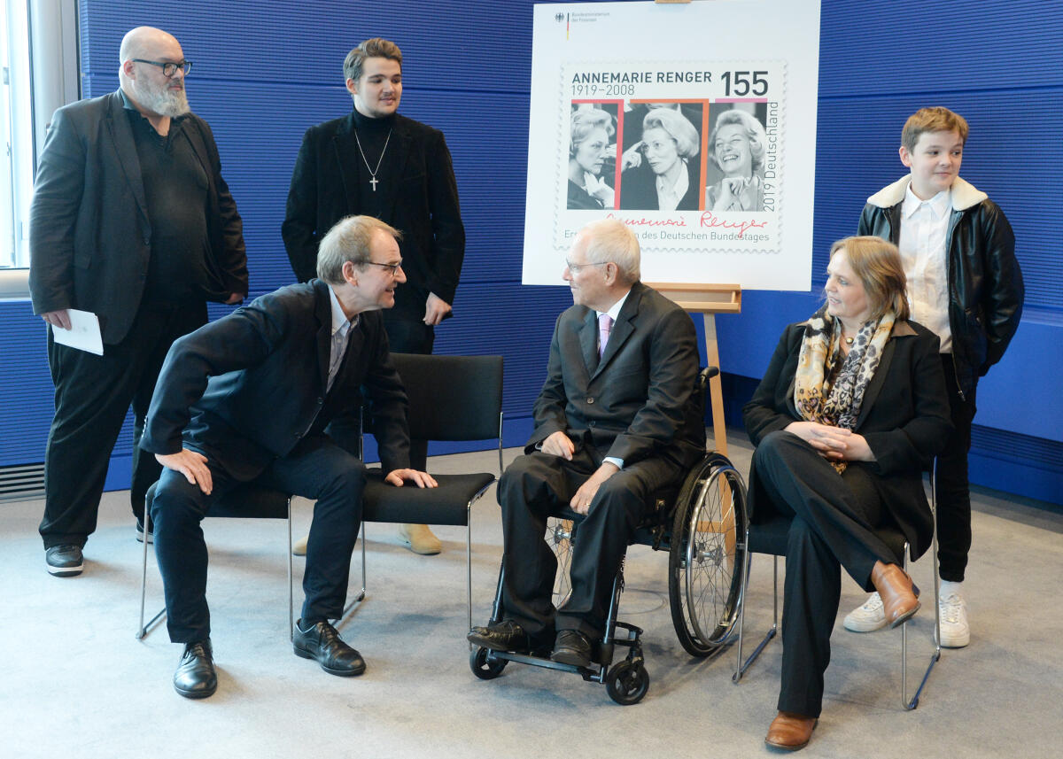 Schäuble, Wolfgang; Schick, Claudia; Renger, Reinhard; Schick, Alexander; Schick, Patrick Glen; Schick, David Miles Bundestagspräsident Dr. Wolfgang Schäuble, (mitte), CDU/CSU, nimmt von Bundesminister Olaf Scholz, (nicht im Bild), SPD,  ein Sonderpostwertzeichen aus Anlass des 100. Geburtstages von Annemarie Renger, der ersten (1.) Präsidentin (1972 bis 1976) des Deutschen Bundestages, entgegen. Renger gehörte von 1953 bis 1990 dem Bundestag an. An der Übergabe der Sonderbriefmarke, die von Julia Neller entworfen wurde, waren Familienangehörige Rengers zugegen. Die Enkelin Claudia Schick, (sitzend re), der Enkel Reinhard Renger, (sitzend li), der Ehemann der Enkelin, Alexander Schick, (stehend li), und die Urenkel Patrick Glen Schick (stehend 2.v.li) und David Miles Schick (stehend re).; Briefmarke, Geste, Gestik.