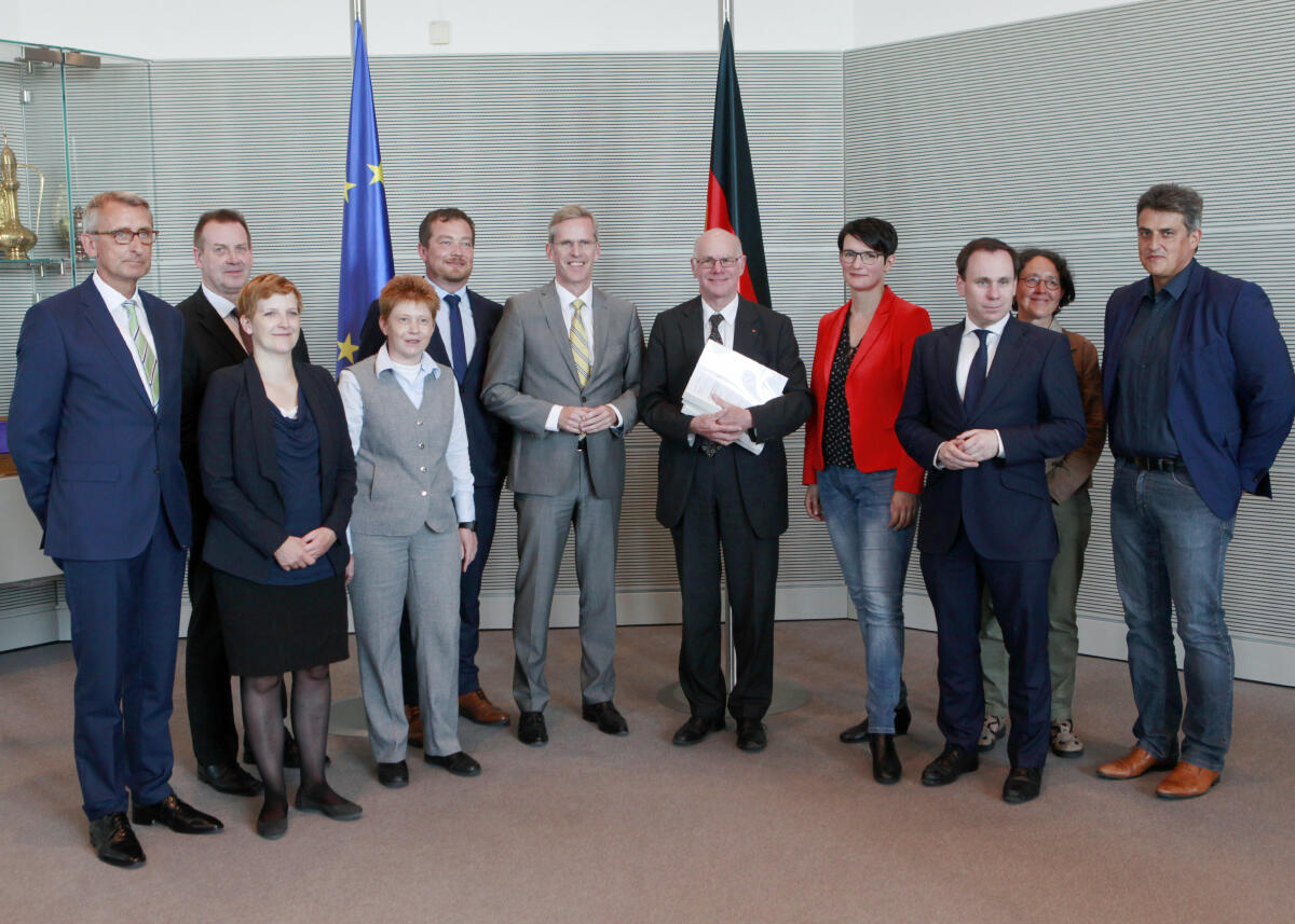 Lammert, Norbert; Binninger, Clemens; Pau, Petra Bundestagspräsident Prof. Dr. Norbert Lammert, (5.v.re), CDU/CSU, nimmt im Beisein der Mitglieder des Ausschusses, u.a. Bundestagsvizepräsidentin Petra Pau, (4.v.li), DIE LINKE, vom Vorsitzenden des 3. UA, Clemens Binninger, CDU/CSU, den Bericht des 3. Untersuchungsausschusses, (NSU II), entgegen.; Fahne, Fahnen, Gruppenfoto.