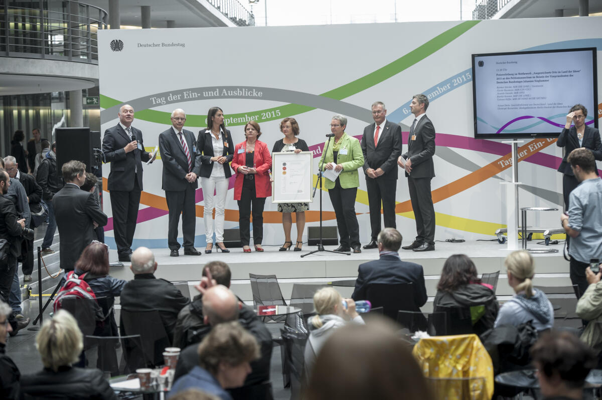 Singhammer, Johannes; Steinke, Kersten; Baumann, Günter; Sawade, Annette; Kassner, Kerstin Tag der Ein- und Ausblicke (Tag der offenen Tür) im Deutschen Bundestag. Bundestagsvizepräsident Johannes Singhammer, CDU/CSU, (2. v.r.), bei der Preisverleihung im Wettbewerb "Ausgezeichnete Orte im Land der Ideen" an den Petitionsausschuss des Deutschen Bundestages zusammen mit Vorsitzende des Peititionsausschusses Kerstin Steinke, MdB, DIE LINKE (3. v.r.), Günter Baumann, MdB CDU/CSU, (2. v.l.), Annette Sawade, MdB, SPD, (4. v.l.), Kerstin Kassner, MdB, DIE LINKE, (4. v.r.), alle Mitglieder des Peitionsausschusses, sowie Ariane Derks, Geschäftsführerin von Deutschland - Land der Ideen, (3. v.l.), und Christoph Burmeister , Deutsche Bank AG, (rechts).; Vizepräsident, Deutscher Bundestag, TEA, Besucher, Verleihung, Sichere E-Petitionen