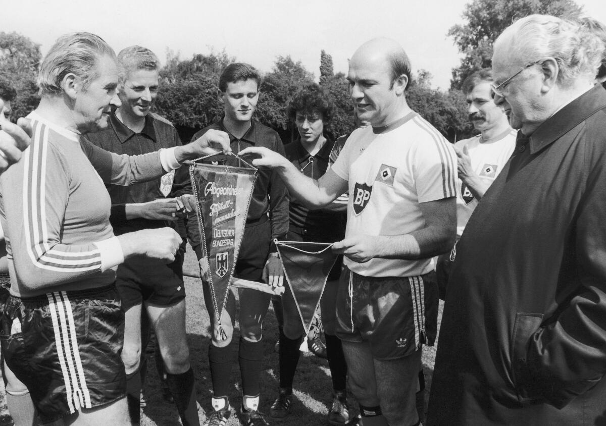 Müller-Emmert, Adolf; Stücklen, Richard Fußballspiel der Abgeordneten-Fußballmannschaft des Deutschen Bundestages gegen die Traditionsmannschaft des HSV. Hier: Dr. Adolf Müller-Emmert (li.), SPD, MdB und der Mannschaftsführer des HSV tauschen die Mannschafts-Wimpel aus. Rechts Bundestagsvizepräsident Richard Stücklen, CDU/CSU.; Fußball, Abgeordnete, Bundestagsabgeordnete, Wimpel, Fußballfeld, Vizepräsident