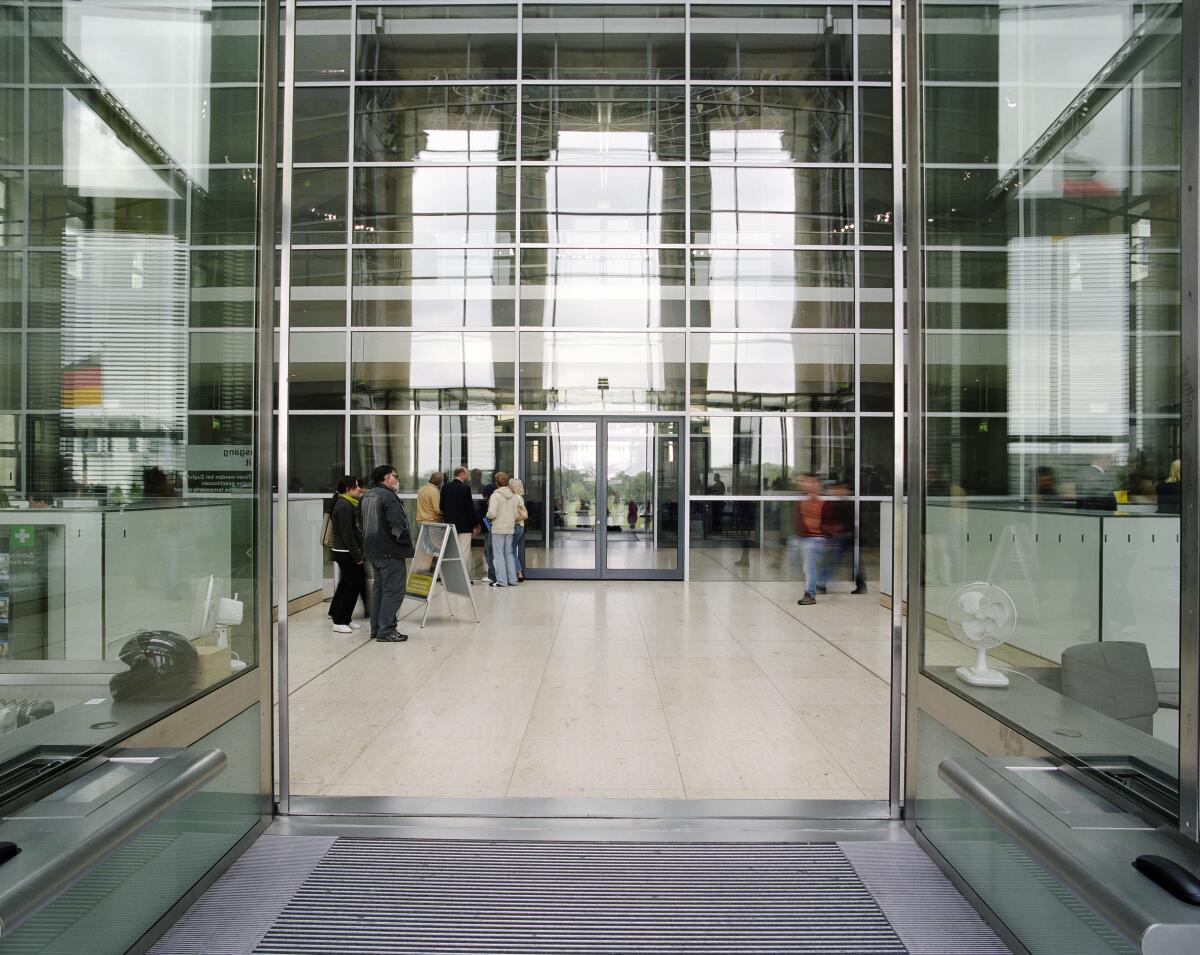 Pförtnerlogen in der Eingangsalle des Reichstagsgebäudes mit Blick Richtung Osten.; Besucher, Verglasung, Spiegelung, Halle, Innenansicht, Westeingang, West Pförtnerlogen in der Eingangsalle des Reichstagsgebäudes mit Blick Richtung Osten.; Besucher, Verglasung, Spiegelung, Halle, Innenansicht, Westeingang, West