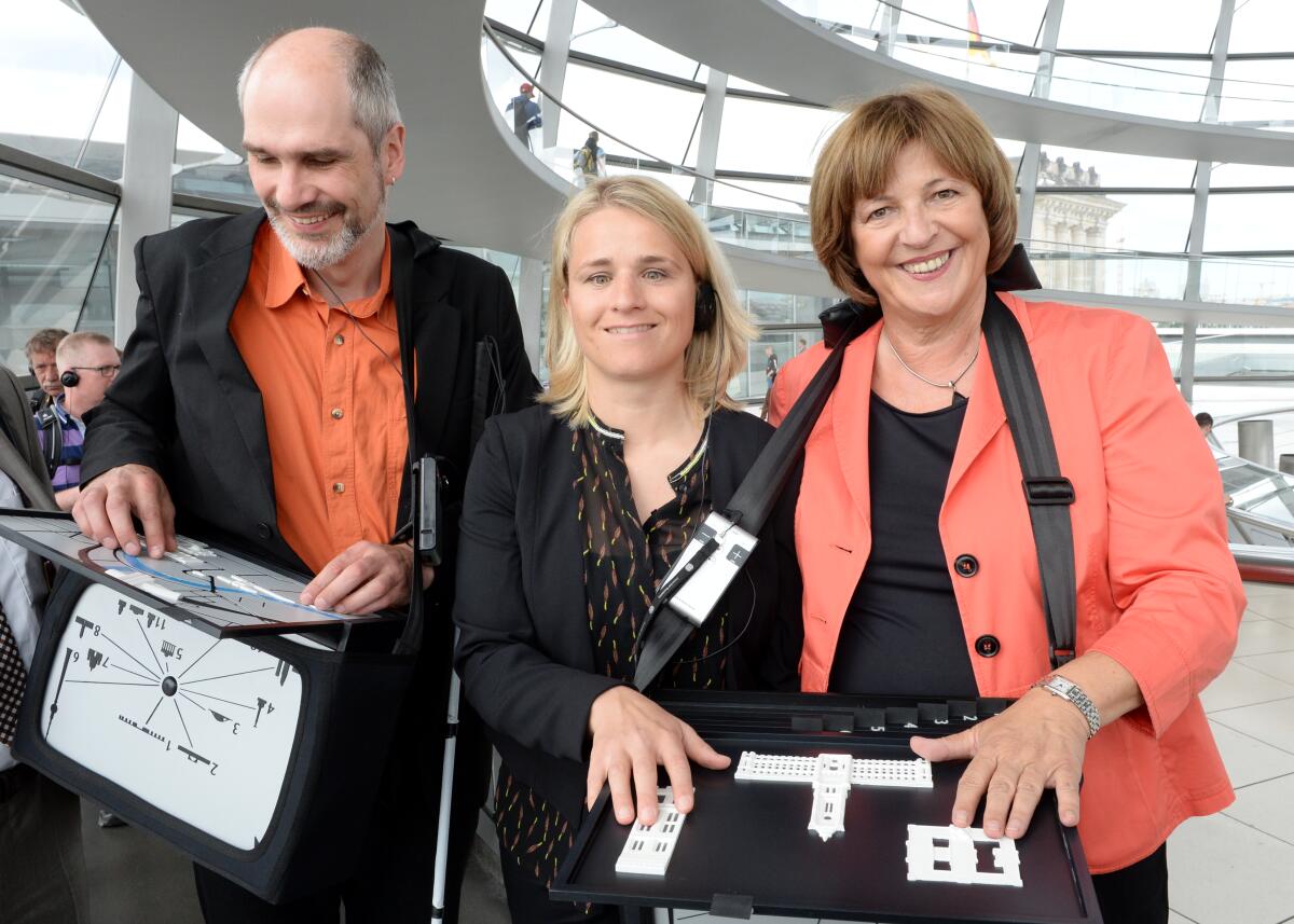 Schmidt, Ulla; Bentele, Verena; Delgado, Reiner Bundestagsvizepräsidentin Ulla Schmidt, (re), SPD, präsentiert der Behindertenbeauftragten der Bundesregierung, Verena Bentele, (mitte), den Bundestags-Audioguide für Sehbehinderte. Reiner Delgado, (li), Sozialreferent des Deutschen Blinden- und Sehbehindertenverbandes e. V., nimmt an dem Termin teil.