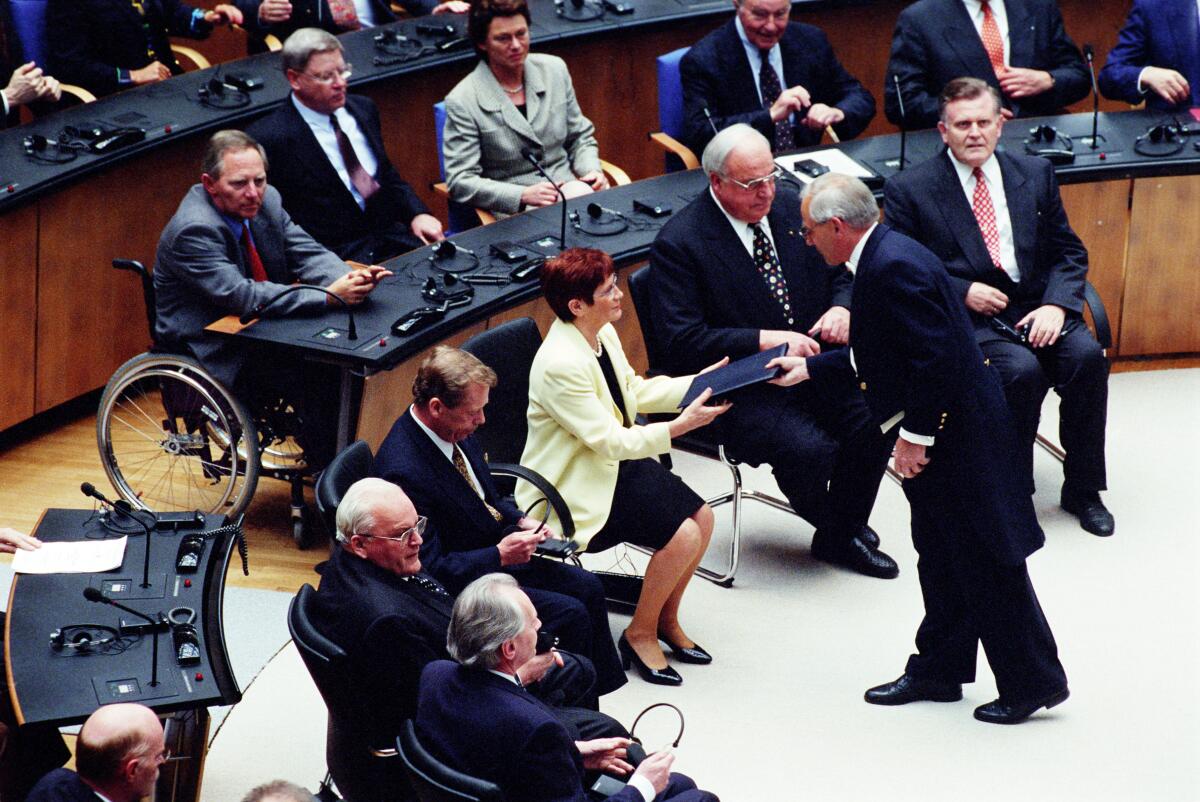 Havel, Vaclav; Süssmuth, Rita; Kohl, Helmut; Schäuble, Wolfgang Vaclav Havel, der erste Staatspräsident der Tschechischen Republik, zu Besuch im Deutschen Bundestag auf Einladung der Bundestagspräsidentin Prof. Dr. Rita Süssmuth, CDU/CSU, MdB am 24. April 1997.; Hier: Ein Plenarassistent übergibt Bundestagspräsidentin Prof. Dr. Rita Süssmuth, CDU/CSU, MdB, ihre Rede. Daneben: Vaclac Havel, Staatspräsident Tschechiens (links) und Bundeskanzler Helmut Kohl, CDU/CSU, MdB (rechts).; Präsident, Präsidentin, Bundeskanzler, Abgeordnete, Bundestagsabgeordnete