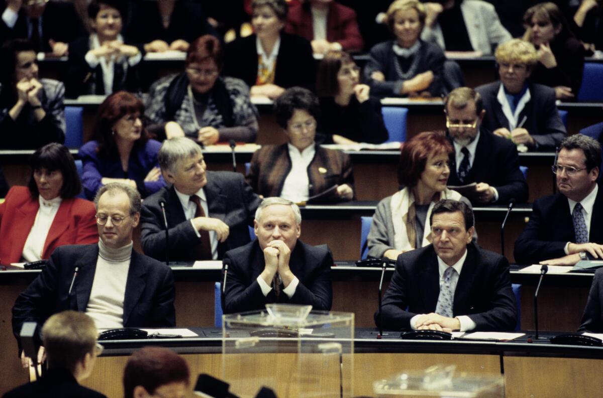 Die Konstituierende Sitzung der 14. Wahlperiode findet im neuen Bonner Plenarsaal statt. Blick auf die SPD-Fraktion. 1. Reihe v.l.n.r.: Fraktionsvorsitzender Rudolf Scharping, MdB, Parteivorsitzender Oskar Lafontaine, MdB, und Kanzlerkandidat Gerhard Schröder, MdB.; Bundestagsabgeordnete, Abgeordnete, Fraktion, Vorsitzende Schröder, Gerhard; Lafontaine, Oskar; Scharping, Rudolf; Schily, Otto; Wieczorek-Zeul, Heidemarie Die Konstituierende Sitzung der 14. Wahlperiode findet im neuen Bonner Plenarsaal statt. Blick auf die SPD-Fraktion. 1. Reihe v.l.n.r.: Fraktionsvorsitzender Rudolf Scharping, MdB, Parteivorsitzender Oskar Lafontaine, MdB, und Kanzlerkandidat Gerhard Schröder, MdB.; Bundestagsabgeordnete, Abgeordnete, Fraktion, Vorsitzende