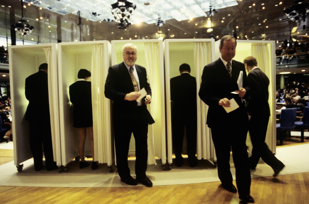 Die Konstituierende Sitzung der 14. Wahlperiode findet im neuen Bonner Plenarsaal statt.; Die Abgeordneten werden in alphabetischer Reihenfolge von den Schriftführern aufgerufen, um sich nach Entgegennahme der Stimmkarte an den Ausgabetischen in die Wahlkabinen zu begeben.; Bundestagsabgeordnete, Abgeordnete, Wahl, wählen, Abstimmung, abstimmen, Stimmzettel, Wahlkabine, Wahlurne, geheim Die Konstituierende Sitzung der 14. Wahlperiode findet im neuen Bonner Plenarsaal statt.; Die Abgeordneten werden in alphabetischer Reihenfolge von den Schriftführern aufgerufen, um sich nach Entgegennahme der Stimmkarte an den Ausgabetischen in die Wahlkabinen zu begeben.; Bundestagsabgeordnete, Abgeordnete, Wahl, wählen, Abstimmung, abstimmen, Stimmzettel, Wahlkabine, Wahlurne, geheim