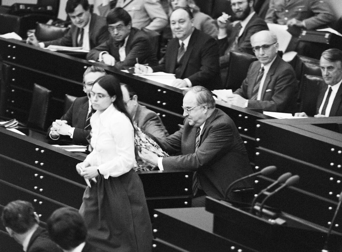 Christa Nickels, DIE GRÜNEN, MdB, verlässt die Regierungsbank im Pleanarsaal, nachdem sie Bundeskanzler Helmut Kohl, CDU, nach ihrer Rede am 22.11.1983 eine Kette aus Kranichen, überreicht hatte.; Bundestagsabgeordnete, Abgeordnete, Rednerpult Nickels, Christa; Kohl, Helmut Christa Nickels, DIE GRÜNEN, MdB, verlässt die Regierungsbank im Pleanarsaal, nachdem sie Bundeskanzler Helmut Kohl, CDU, nach ihrer Rede am 22.11.1983 eine Kette aus Kranichen, überreicht hatte.; Bundestagsabgeordnete, Abgeordnete, Rednerpult
