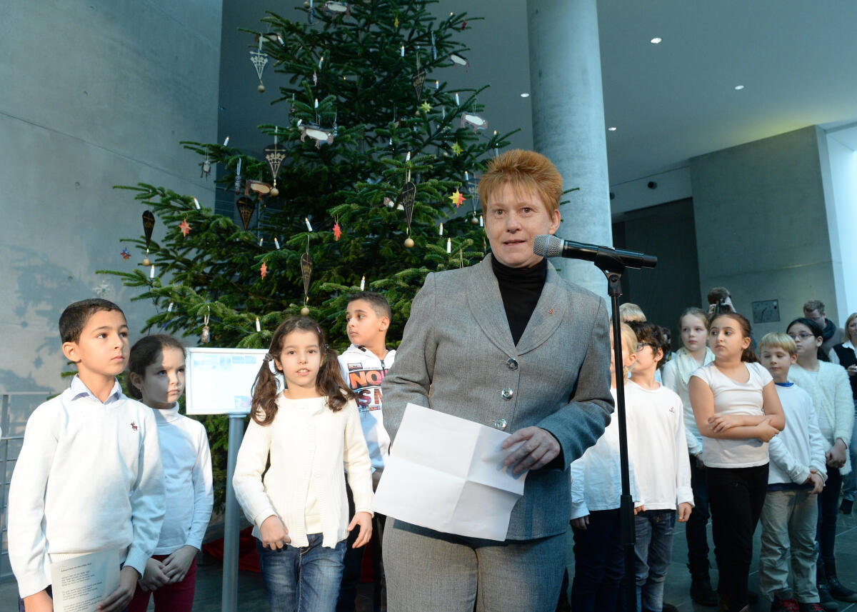 Pau, Petra Bundestagsvizepräsidentin Petra Pau, (am Mikrofon), DIE LINKE, nimmt vor dem Veranstaltungsfoyer im Marie-Elisabeth-Lüders-Haus einen Weihnachtsbaum aus dem Naturpark Sauerland-Rothaargebirge entgegen. Das Märkische Jugendsinfonieorchester begleitet die Übergabe musikalisch. Schüler der Spandauer Grundschule tragen Weihnachtslieder vor.; Weihnachten.