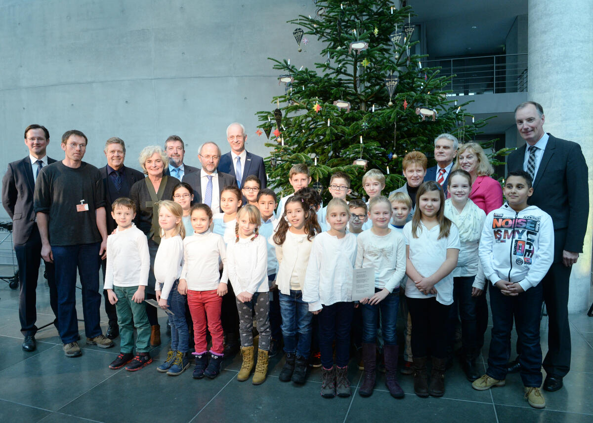 Pau, Petra Bundestagsvizepräsidentin Petra Pau, (hinterer Reihe 4.v.re), DIE LINKE, nimmt vor dem Veranstaltungsfoyer im Marie-Elisabeth-Lüders-Haus einen Weihnachtsbaum aus dem Naturpark Sauerland-Rothaargebirge entgegen. Das Märkische Jugendsinfonieorchester begleitet die Übergabe musikalisch. Schüler der Spandauer Grundschule tragen Weihnachtslieder vor.; Weihnachten, Gruppenfoto.