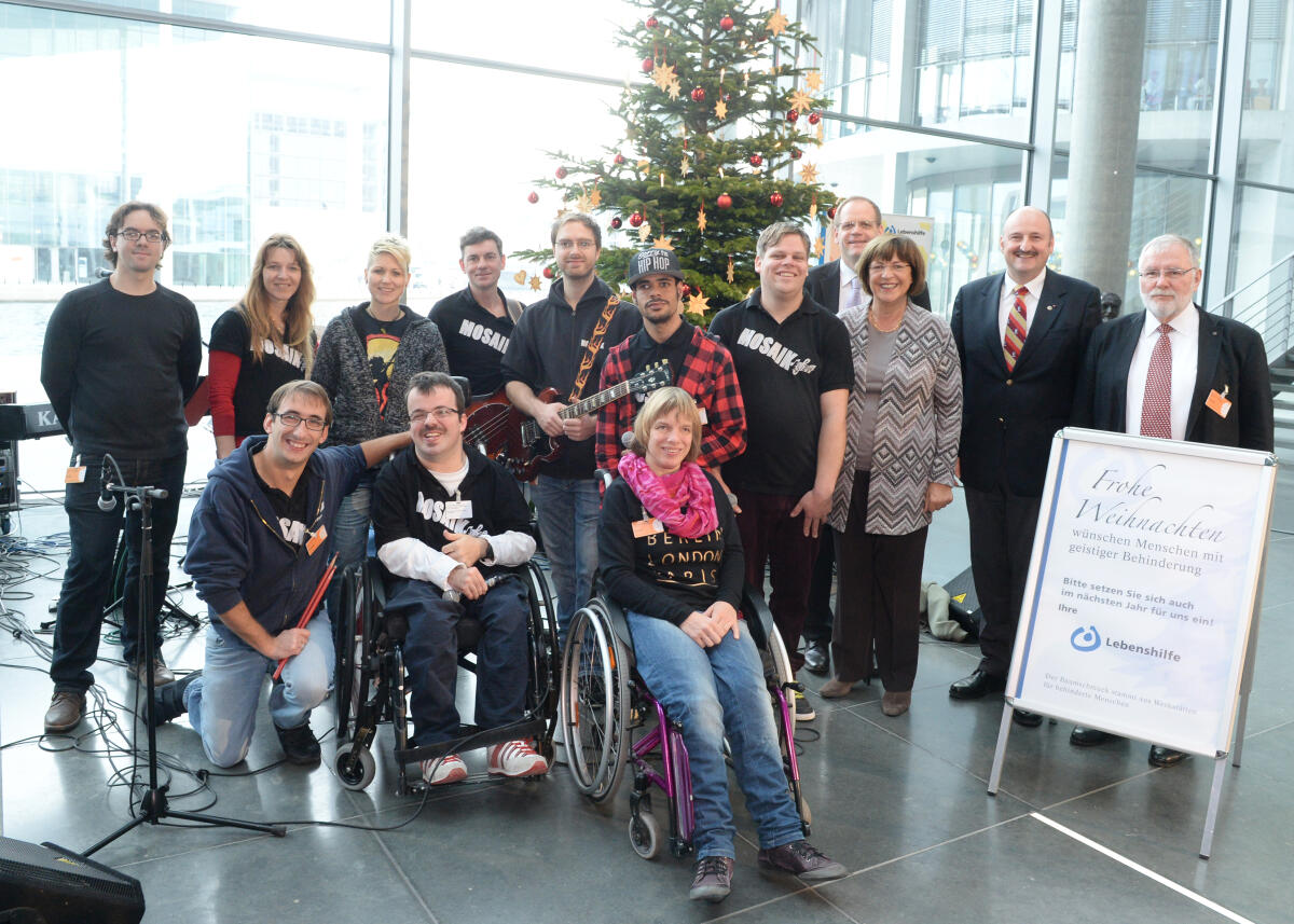 Schmidt, Ulla; Rützel, Bernd Bundestagsvizepräsident Johannes Singhammer, CDU/CSU, nimmt im Namen des Deutschen Bundestages in der Halle des Paul-Löbe-Hauses einen Weihnachtsbaum mit handgefertigtem Schmuck der Lebenshilfe für Menschen mit Behinderungen entgegen. Bundestagsvizepräsidentin und Bundesvorsitzende der Lebenshilfe, Ulla Schmidt, (4.v.re), SPD, eröffnet die Übergabe. Für den musikalischen Rahmen sorgt die Gruppe "Mosaik" (im Bild) aus Ochsenfurt bei Würzburg. An der Veranstaltung nehmen zahlreiche Mitglieder des Bundestages teil, darunter Bernd Rützel (2.v.re) von der SPD.