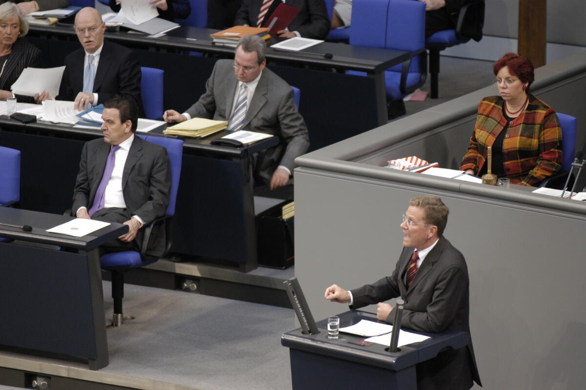Westerwelle, Guido; Schröder, Gerhard; Struck, Peter Der Parteivorsitzende Guido Westerwelle, FDP, MdB, am Rednerpult. In der ersten Reihe der Regierungsbank: Bundeskanzler Gerhard Schröder, SPD, MdB. In der zweiten Reihe links Verteidigungsminister Peter Struck, SPD, MdB, im Plenum.