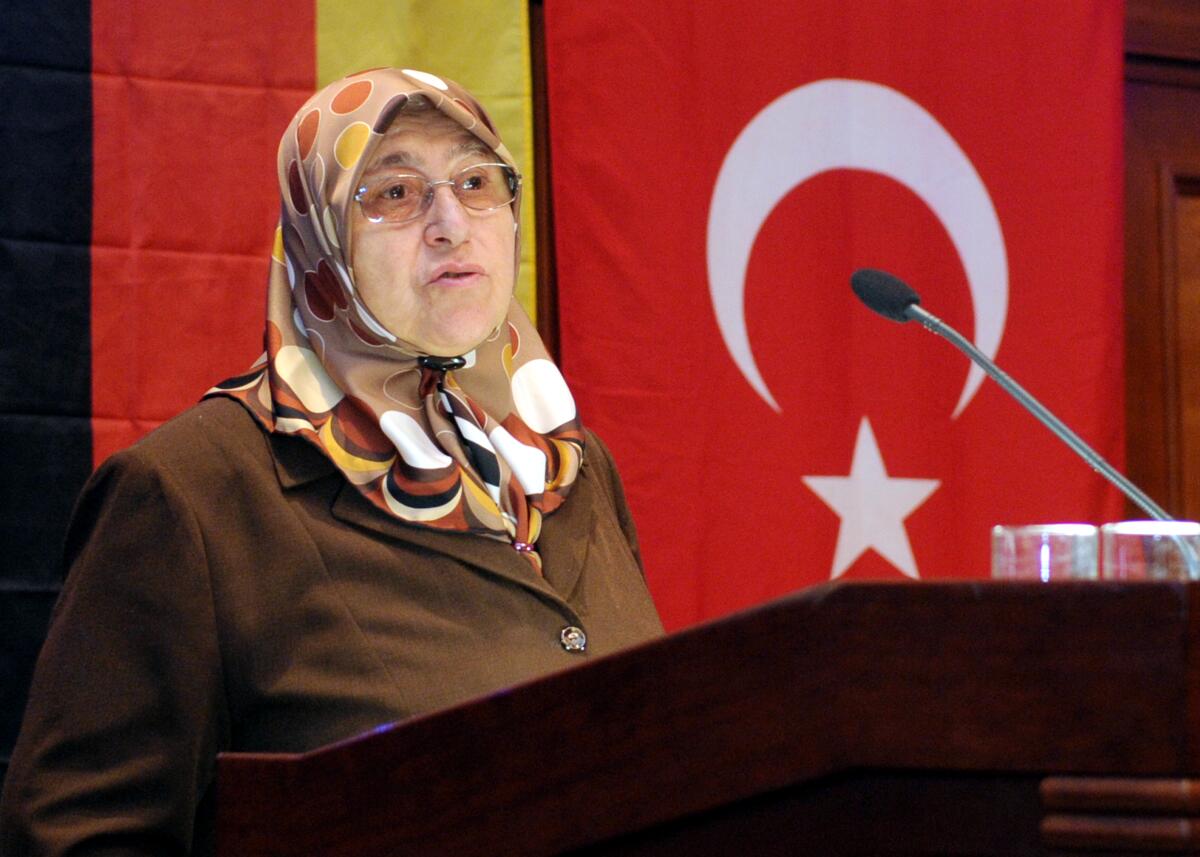 Genc, Mevlüde Verleihung des Genc-Preises an Sebastian Edathy, SPD, für seine Arbeit als Vorsitzender des Untersuchungsausschusses (UA) des Deutschen Bundestages für die NSU-Morde, und an Tülin Özüdogru, Tochter des Mordopfers Abdurrahim Özüdogru, verstorben am 13.06.2001 in Nürnberg. Am 29. Mai 1993 sind in Solingen fünf Frauen und Kinder der Familie Genc bei einem schrecklichen Brandanschlag ums Leben gekommen. Dennoch hat die Familie, vertreten durch die Namensgeberin Mevlüde Genc, (hier im Bild), Versöhnung gegenüber der Gesellschaft gezeigt. Zu diesem Zweck wurde der Genc-Preis geschaffen.; Fahne, Fahnen, Rednerpult, Mikro, Mikrofon.
