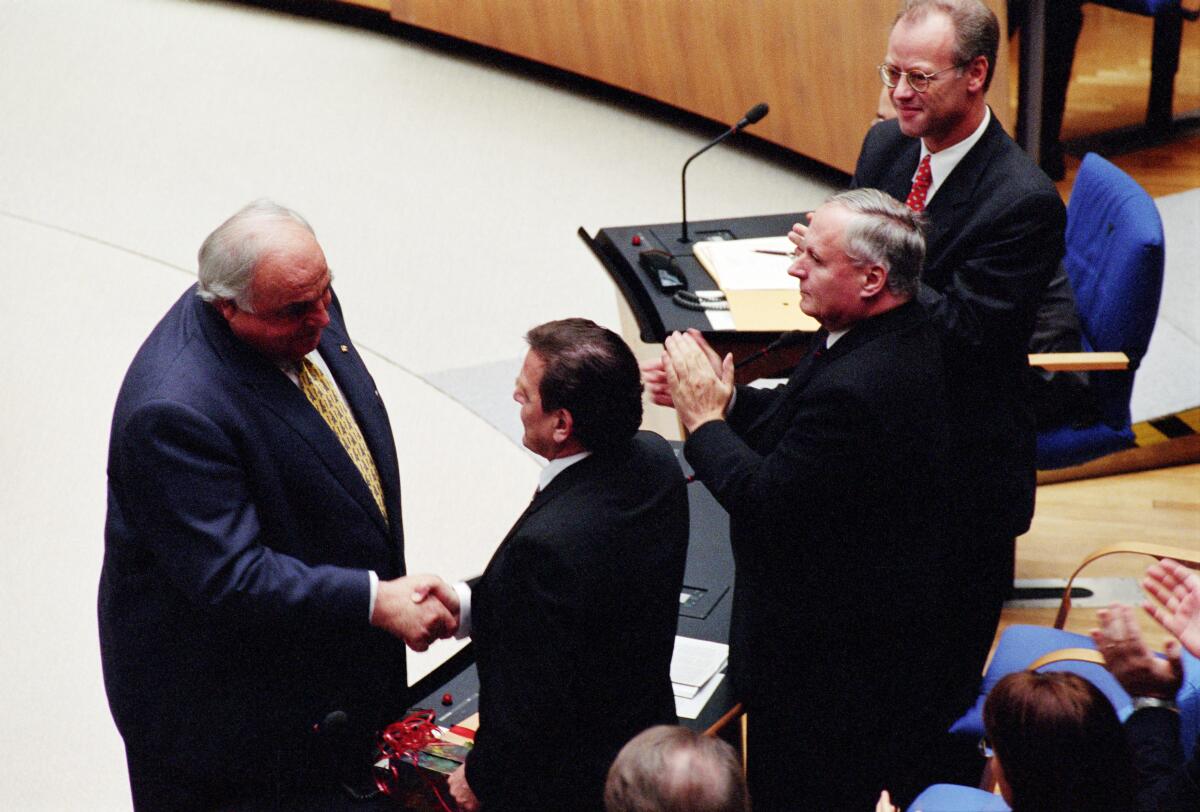 Die Wahl des Bundeskanzlers findet einen Tag nach der Konstituierenden Sitzung am 27. Oktober 1998 im neuen Plenarsaal in Bonn statt. Blick auf die SPD-Fraktion.; Der alte Bundeskanzler Helmut Kohl, CDU/CSU, MdB (links), gratuliert dem neuen Bundeskanzler Gerhard Schröder, SPD, MdB (rechts), zum Wahlsieg.; Gratulation, gratulieren, Applaus, applaudieren Kohl, Helmut; Schröder, Gerhard; Lafontaine, Oskar; Scharping, Rudolf Die Wahl des Bundeskanzlers findet einen Tag nach der Konstituierenden Sitzung am 27. Oktober 1998 im neuen Plenarsaal in Bonn statt. Blick auf die SPD-Fraktion.; Der alte Bundeskanzler Helmut Kohl, CDU/CSU, MdB (links), gratuliert dem neuen Bundeskanzler Gerhard Schröder, SPD, MdB (rechts), zum Wahlsieg.; Gratulation, gratulieren, Applaus, applaudieren
