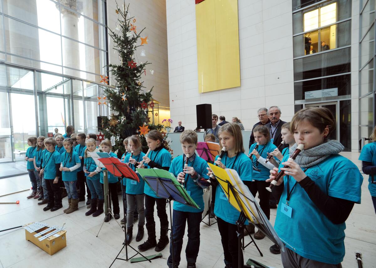  Bundestagspräsident Prof. Dr. Norbert Lammert, CDU/CSU, nimmt im Westfoyer des Reichstagsgebäudes für den Bundestag einen Weihnachtsbaum aus dem Naturpark Dübener Heide entgegen. Schüler und Schülerinnen der Evangelischen Grundschule Bad Düben (hier im Bild) singen und musizieren dazu.; Weihnachten, Musik.