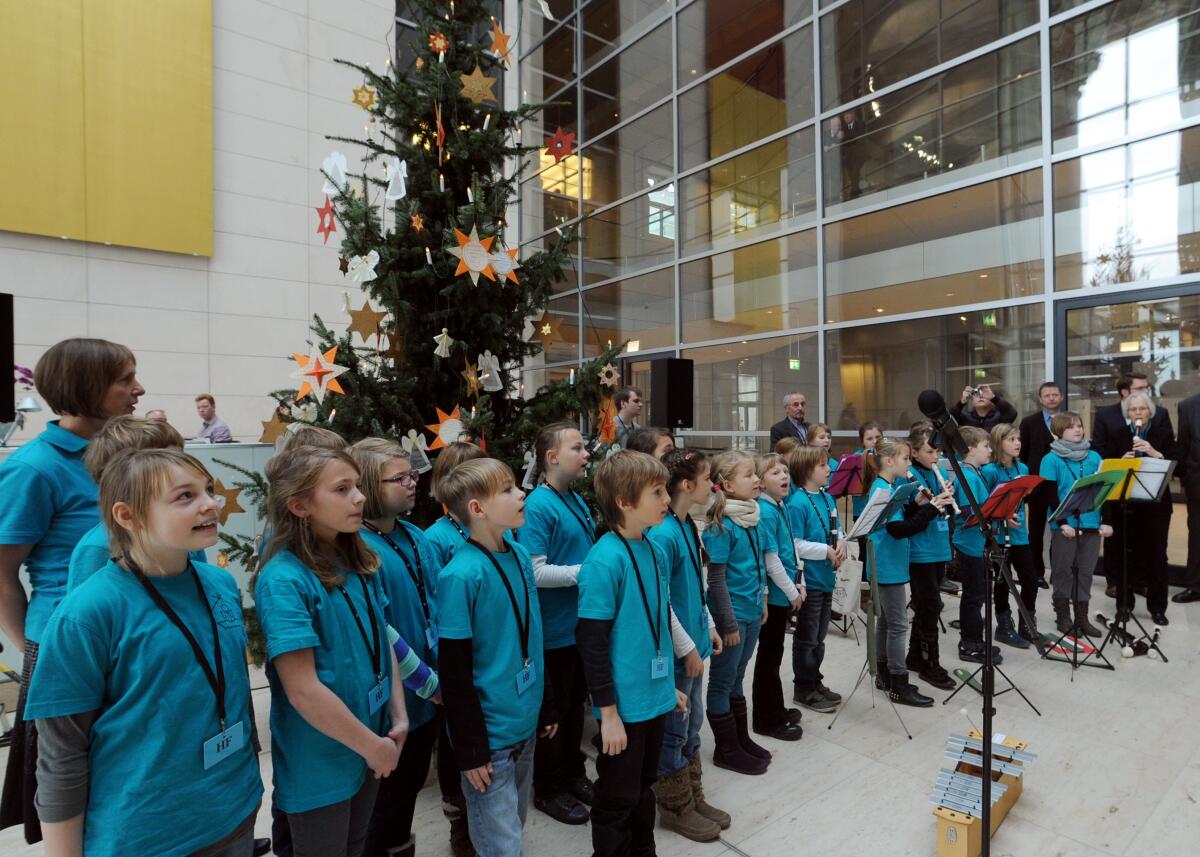  Bundestagspräsident Prof. Dr. Norbert Lammert, CDU/CSU, nimmt im Westfoyer des Reichstagsgebäudes für den Bundestag einen Weihnachtsbaum aus dem Naturpark Dübener Heide entgegen. Schüler und Schülerinnen der Evangelischen Grundschule Bad Düben (hier im Bild) singen und musizieren dazu.; Weihnachten, Musik.