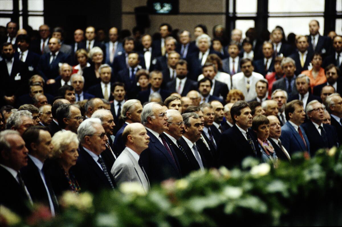 Herzog, Roman Wahl Roman Herzogs zum Bundespräsidenten, 10. Bundesversammlung am 23. Mai 1994 im Plenarsaal des Reichstagsgebäudes Berlin. Roman Herzog (7.v.l.) mit Abgeordneten in einer Reihe stehend und Nationalhymne singend, v.l.n.r.: Ministerpräsident Johannes Rau, SPD; Vorsitzender der SPD-Bundestagsfraktion Hans-Ulrich Klose; ehemalige Bundestagsvizepräsidentin Annemarie Renger, SPD; Vorsitzender der SPD-Bundestagsfraktion Hans-Jochen Vogel; Parlamentarischer Geschäftsführer der SPD-Bundestagsfraktion Peter Struck; Bundeskanzler Helmut Kohl, CDU/CSU; Bundesfinanzminister Theodor Waigel, CDU/CSU; Vorsitzender der CSU-Landesgruppe Michael Glos; Bundesministerin für Frauen und Jugend Angela Merkel, CDU/CSU; Bundesminister für Arbeit und Soziales Norbert Blüm, CDU/CSU; Regierender Bürgermeister von Berlin Eberhard Diepgen, CDU/CSU.; Versammlung, Plenarsaal, Entscheidung, Bundespräsidentenwahl, Abschluss, singen