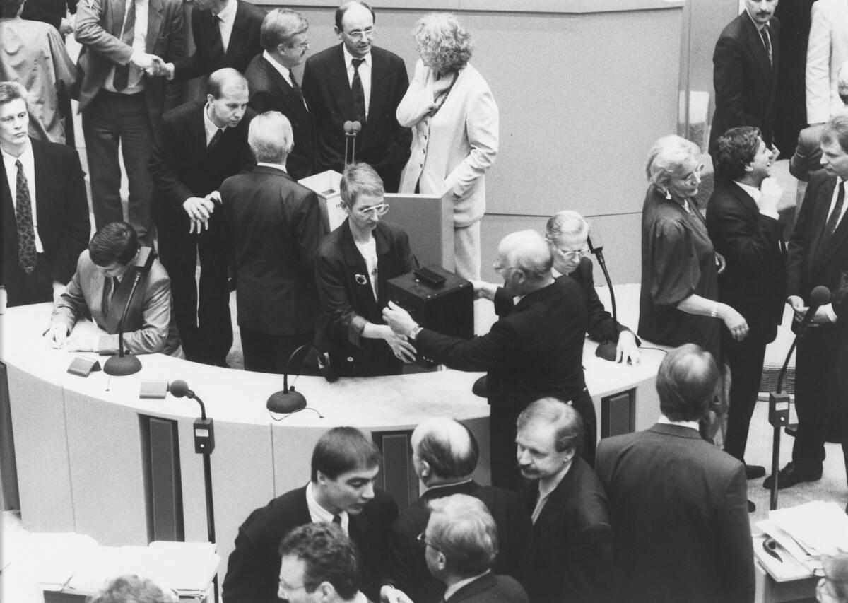  Übergabe der Wahlurne während der 34. Plenarsitzung des Deutschen Bundestages zum Umzug des Bundestages nach Berlin. Abstimmung Bonn-Berlin. Debatte am 20.06.1991 im Plenarsaal Wasserwerk, Bonn. Abgeordnete während der Übergabe der Wahlurne im Gespräch.