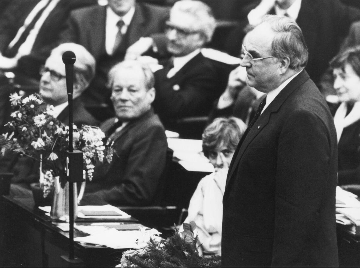 Wahl des Bundeskanzlers Dr. Helmut Kohl, CDU/CSU, MdB am 29. März 1983.; Helmut Kohl nimmt die Wahl an, im Hintergrund: Petra Kelly, Die Grünen, MdB; Alterspräsident Willy Brandt, SPD und der Oppositionsführer Dr. Hans-Jochen Vogel, SPD, MdB.; Wahl, Bundeskanzler, Kanzler, Blumen Kohl, Helmut; Brandt, Willy; Kelly, Petra; Vogel, Hans-Jochen Wahl des Bundeskanzlers Dr. Helmut Kohl, CDU/CSU, MdB am 29. März 1983.; Helmut Kohl nimmt die Wahl an, im Hintergrund: Petra Kelly, Die Grünen, MdB; Alterspräsident Willy Brandt, SPD und der Oppositionsführer Dr. Hans-Jochen Vogel, SPD, MdB.; Wahl, Bundeskanzler, Kanzler, Blumen