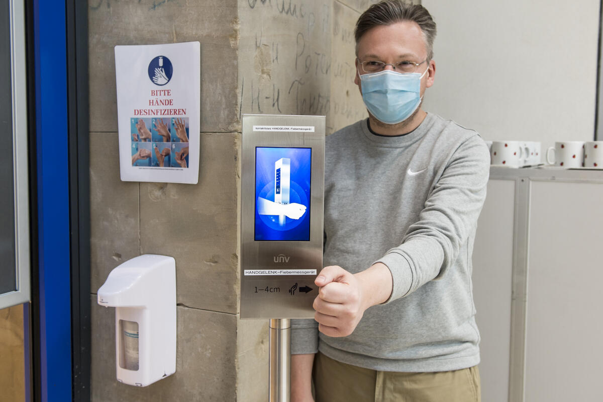 Ein Mann hält sein Handgelenk an den Sensor des kontaktlosen Handgelenk-Fiebermessgerätes am Eingang der Cafeteria im Reichstagsgebäude. Das Gerät misst die Körpertemperatur und gibt ein Signal bei erhöhter Körpertemperatur. Ein Mann hält sein Handgelenk an den Sensor des kontaktlosen Handgelenk-Fiebermessgerätes am Eingang der Cafeteria im Reichstagsgebäude. Das Gerät misst die Körpertemperatur und gibt ein Signal bei erhöhter Körpertemperatur.