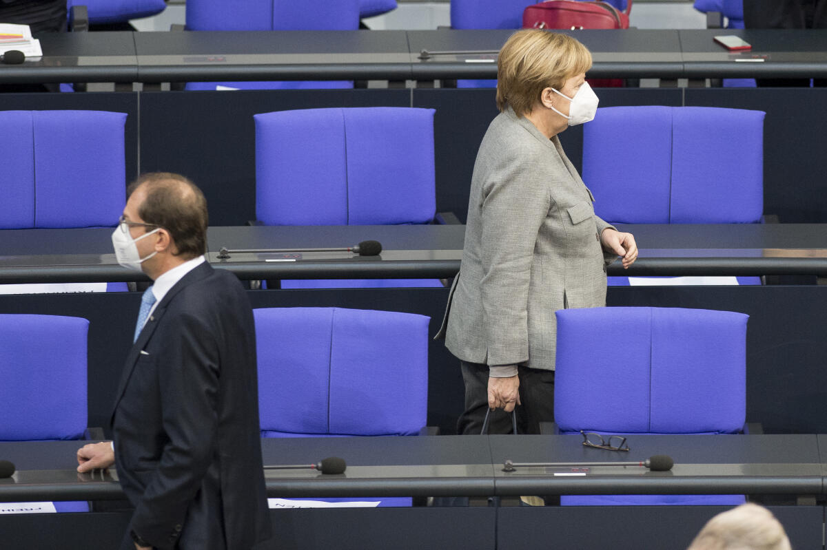 Bundestagssitzung mit dem TOP1 zu Corona-Maßnahmen (epidemische Lage) - vor Beginn der Sitzung: Bundeskanzlerin Angela Merkel (r), CDU/CSU, MdB, geht mit Maske zu ihrem Platz auf der Regierungsbank; Alexander Dobrindt (l), CDU/CSU, MdB, steht mit Maske vor der Regierungsbank. Merkel, Angela; Dobrindt, Alexander Bundestagssitzung mit dem TOP1 zu Corona-Maßnahmen (epidemische Lage) - vor Beginn der Sitzung: Bundeskanzlerin Angela Merkel (r), CDU/CSU, MdB, geht mit Maske zu ihrem Platz auf der Regierungsbank; Alexander Dobrindt (l), CDU/CSU, MdB, steht mit Maske vor der Regierungsbank.