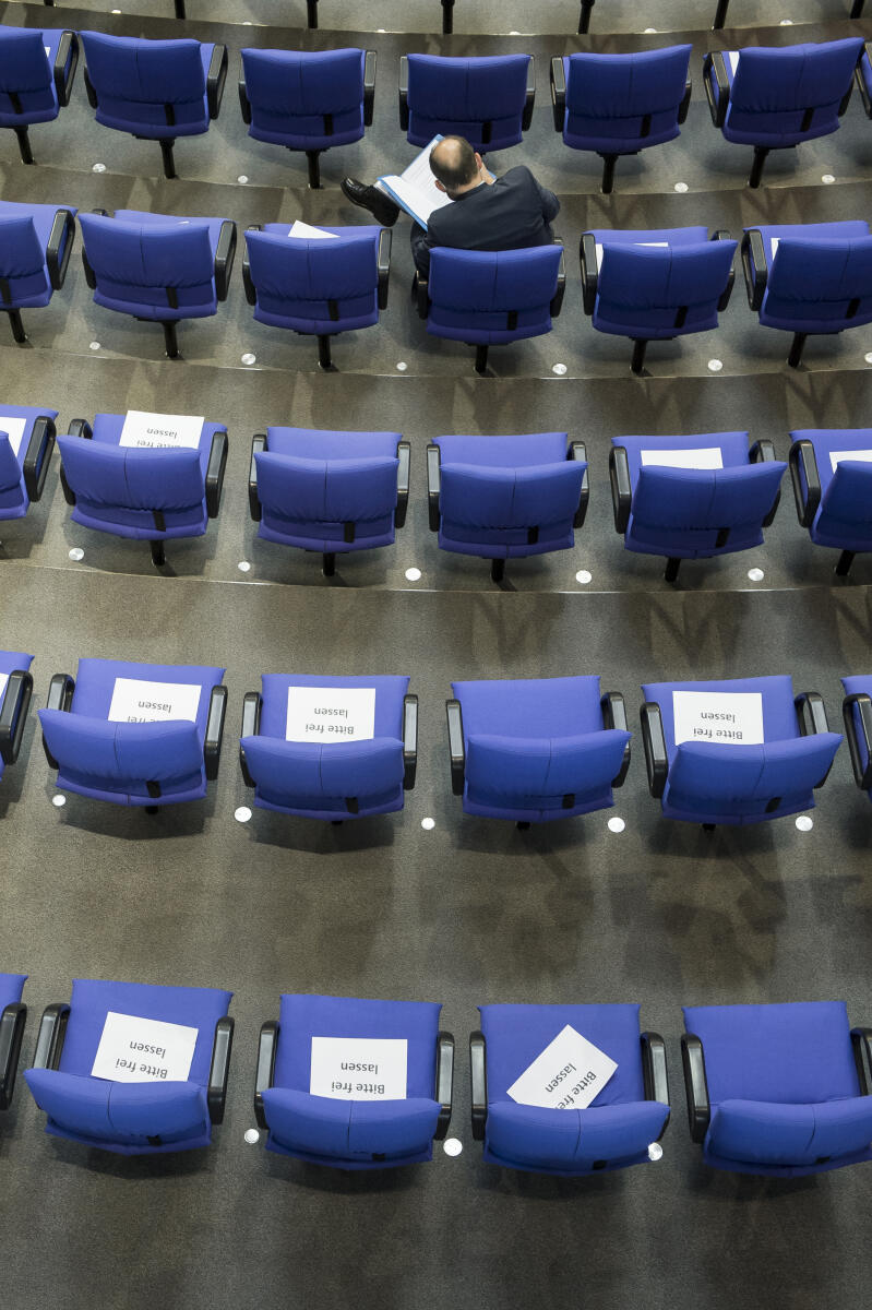 Sitze im Plenum des Deutschen Bundestages sind mit Zetteln zur Abstandsregelung aufgrund der Covid-19-Pandemie belegt. Sitze im Plenum des Deutschen Bundestages sind mit Zetteln zur Abstandsregelung aufgrund der Covid-19-Pandemie belegt.