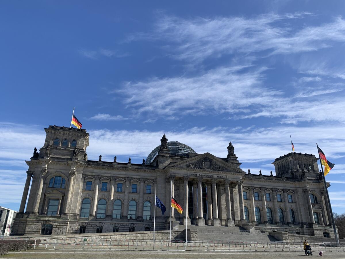 Die Beflaggung des Reichstagsgebäudes mit blauem Himmel Die Beflaggung des Reichstagsgebäudes mit blauem Himmel