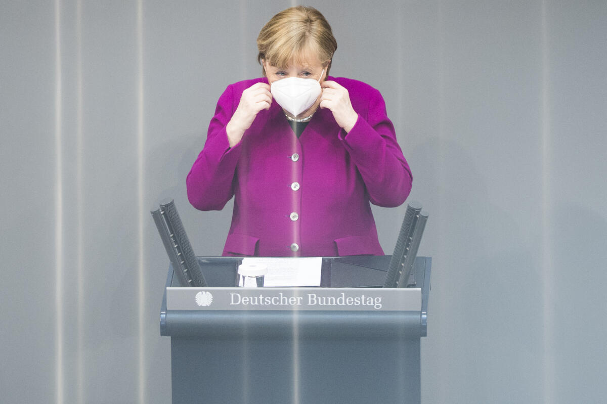 Bundeskanzlerin Dr. Angela Merkel (im Bild), CDU/CSU, MdB, nimmt vor Beginn ihrer Rede vor dem Plenum ihre Gesichtsmaske aufgrund der Covid-19-Pandemie ab. Merkel, Angela Bundeskanzlerin Dr. Angela Merkel (im Bild), CDU/CSU, MdB, nimmt vor Beginn ihrer Rede vor dem Plenum ihre Gesichtsmaske aufgrund der Covid-19-Pandemie ab.