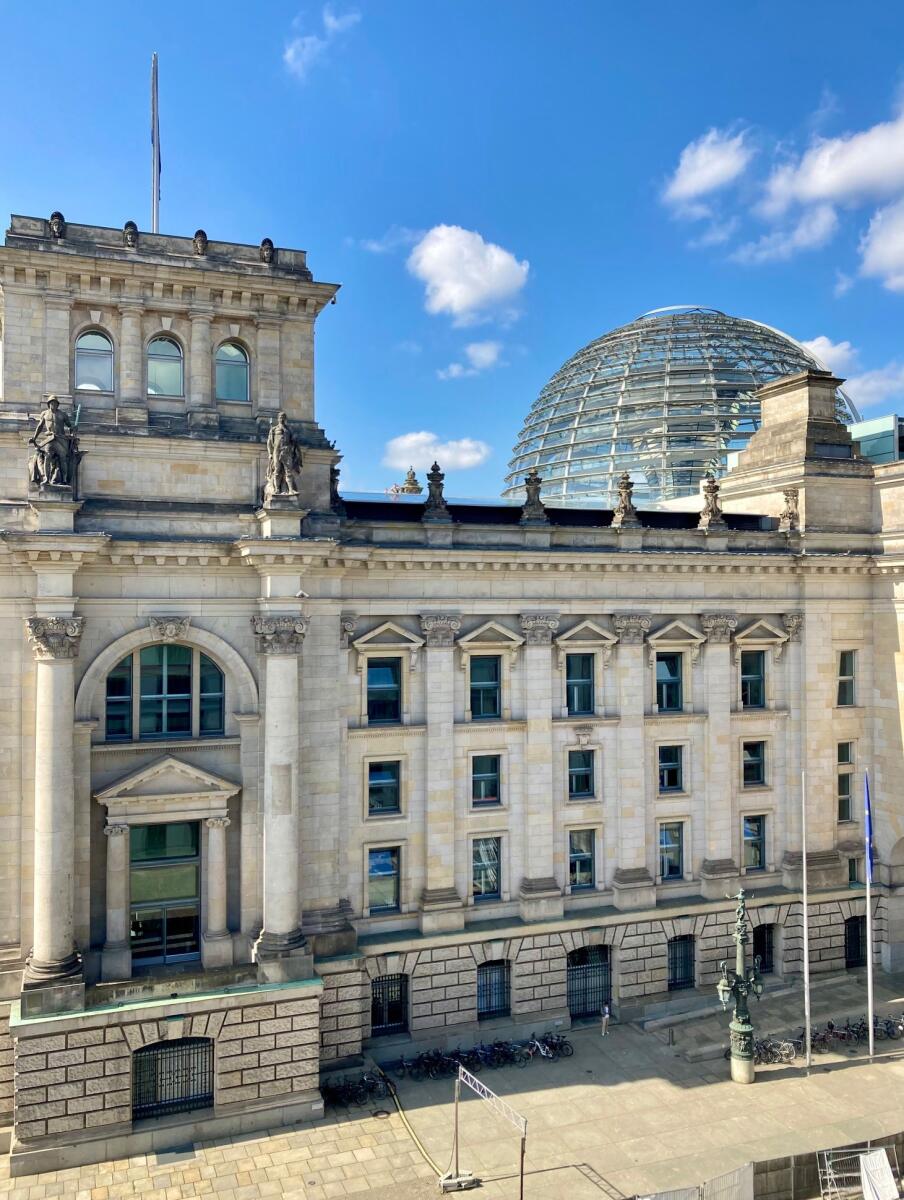  Blick auf einen Teil des Reichstagsgebäudes und der Kuppel an einem sonnigen Sommertag