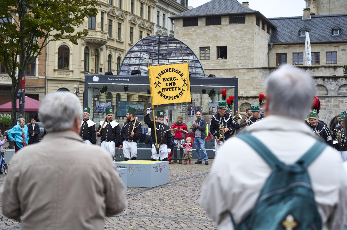 Die Trachtengruppe Freiberger Berg- und Hüttenknappschaft auf dem Hallmarkt in Halle (Saale) vor dem Glaskubus mit Informationen über den Deutschen Bundestag am Eröffnungstag der Einheits-EXPO in Halle (Saale). Zum Tag der deutschen Einheit am 3.Oktober werden die diesjährigen Feierlichkeiten vom 18.09.21 bis zum 03.10.21 in Halle (Saale) abgehalten. Auf dem Hallmarkt sind sämtliche Verfassungsorgane mit Ständen und kleinen Ausstellungen vertreten. Die Trachtengruppe Freiberger Berg- und Hüttenknappschaft auf dem Hallmarkt in Halle (Saale) vor dem Glaskubus mit Informationen über den Deutschen Bundestag am Eröffnungstag der Einheits-EXPO in Halle (Saale). Zum Tag der deutschen Einheit am 3.Oktober werden die diesjährigen Feierlichkeiten vom 18.09.21 bis zum 03.10.21 in Halle (Saale) abgehalten. Auf dem Hallmarkt sind sämtliche Verfassungsorgane mit Ständen und kleinen Ausstellungen vertreten.
