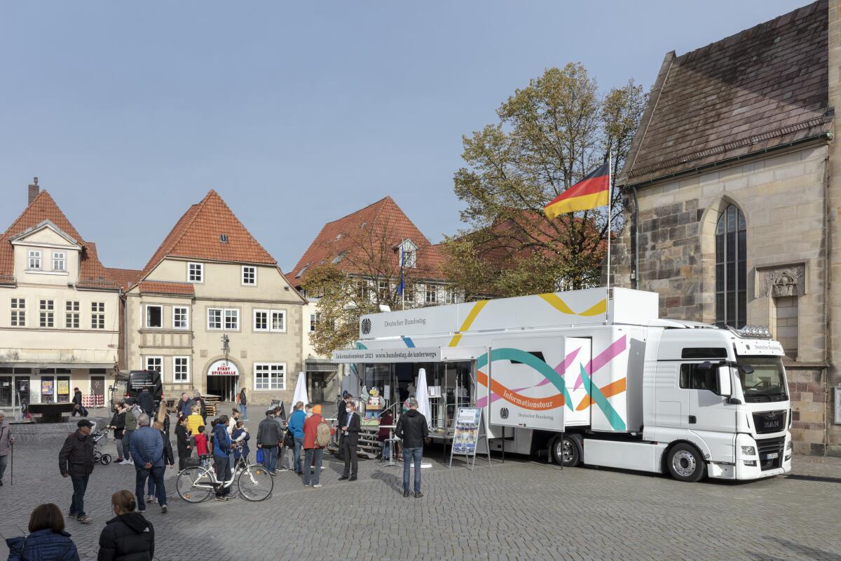 Außenansicht des Infomobils des Deutschen Bundestages mit Besuchern auf dem Pferdemarkt in Hameln. Außenansicht des Infomobils des Deutschen Bundestages mit Besuchern auf dem Pferdemarkt in Hameln.
