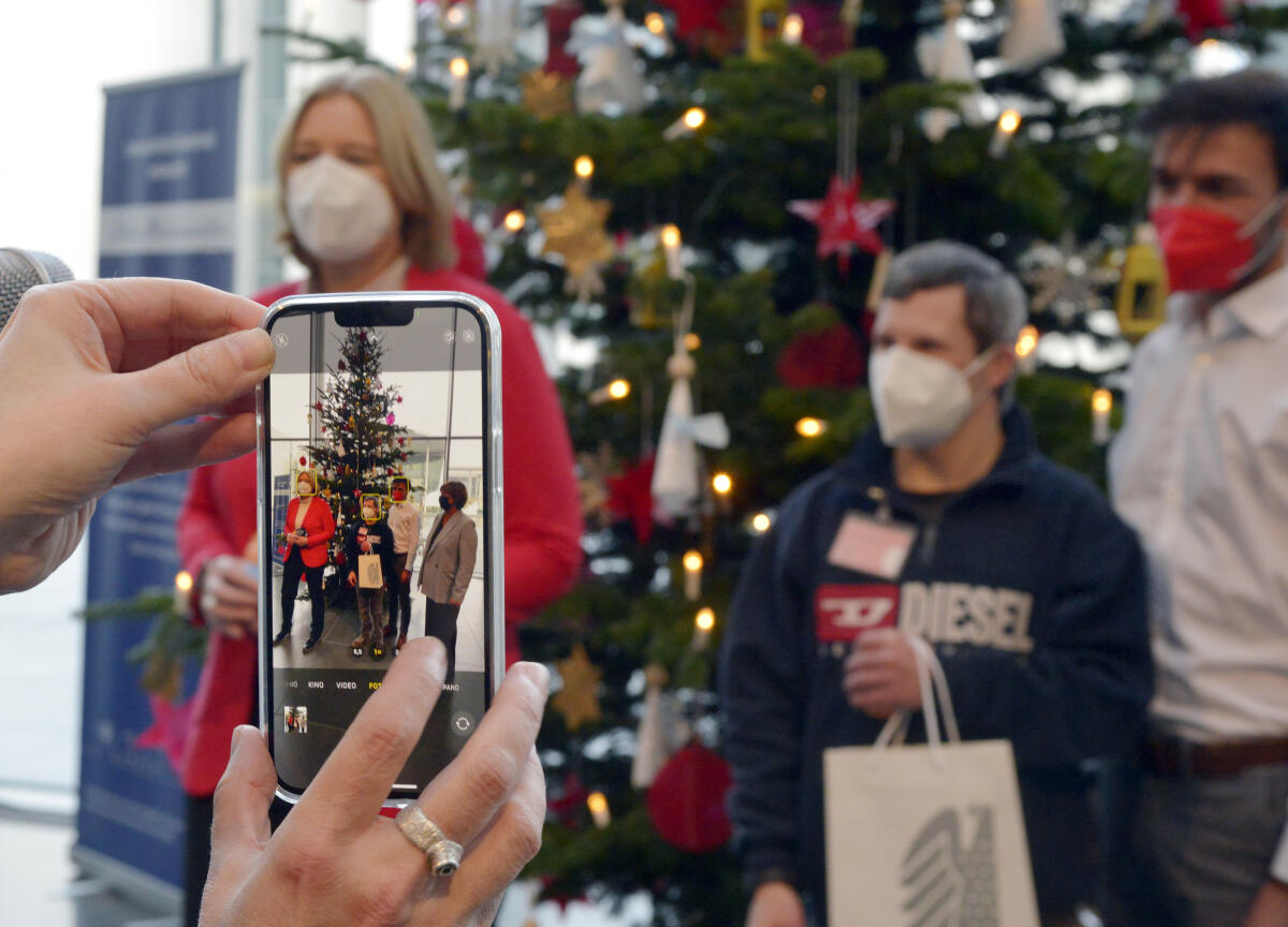 Blick auf ein Smartphone während Bundestagspräsidentin Bärbel Bas, SPD, einen Weihnachtsbaum der Lebenshilfe Berlin e.V. im Paul-Löbe-Haus entgegen nimmt. Den Baumschmuck haben Mitarbeiterinnen und Mitarbeiter der Werkhaus GmbH gefertigt, eine Werkstatt für Menschen mit Behinderung der Lebenshilfe Bielefeld. Bas, Bärbel Blick auf ein Smartphone während Bundestagspräsidentin Bärbel Bas, SPD, einen Weihnachtsbaum der Lebenshilfe Berlin e.V. im Paul-Löbe-Haus entgegen nimmt. Den Baumschmuck haben Mitarbeiterinnen und Mitarbeiter der Werkhaus GmbH gefertigt, eine Werkstatt für Menschen mit Behinderung der Lebenshilfe Bielefeld.