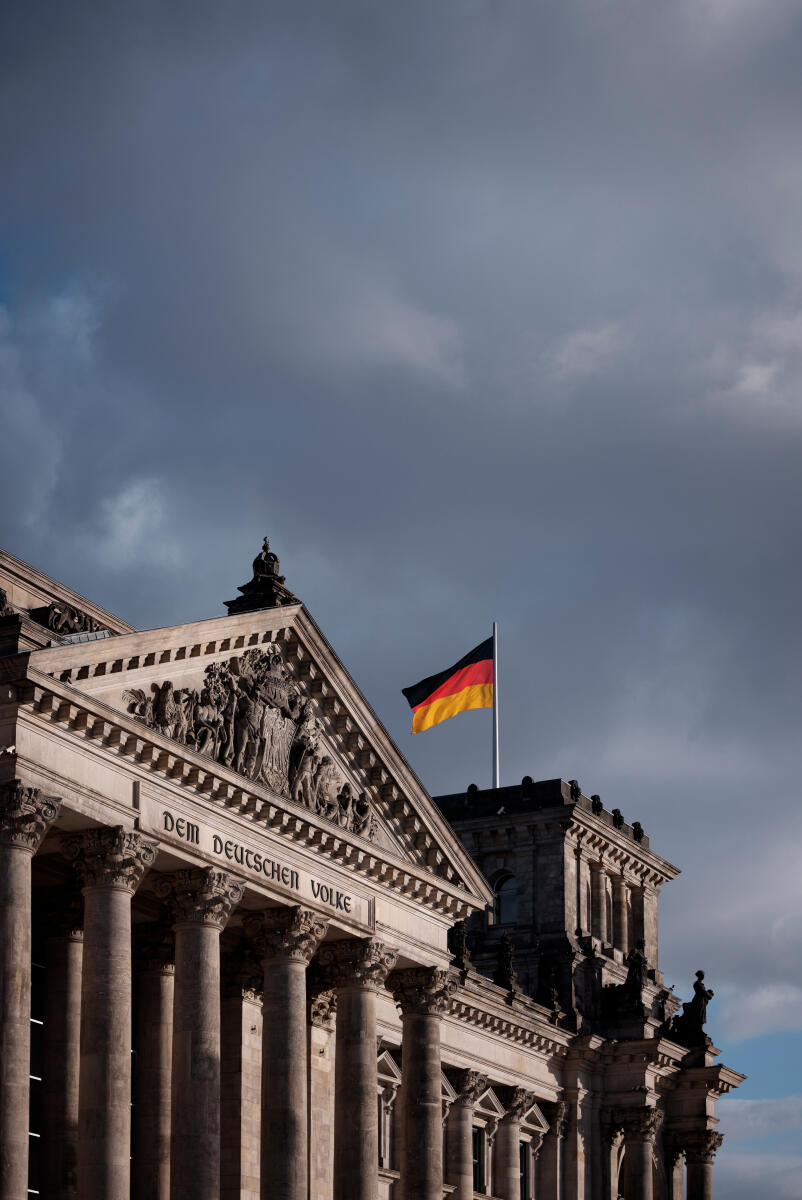  Das Westportal des Reichstags mit der Inschrift „Dem deutschen Volke“. Auf dem Eckturm weht die Deutschlandfahne. 