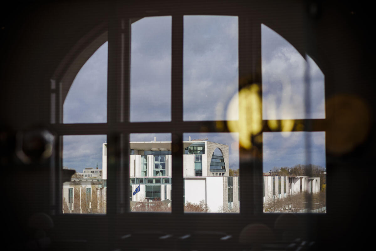  Das Bundeskanzleramt spiegelt sich in einem Fenster im Reichstagsgebäude.