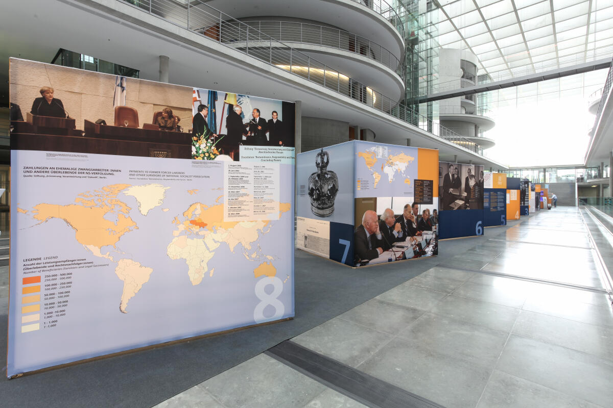  Dokumentation der Ausstellung anlässlich 70 Jahre Luxemburger Abkommen zur Wiedergutmachung nationalsozialistischen Unrechts. Blick auf die Ausstellungsexponate in der Halle des Paul-Läbe-Hauses.; Das von der Bundesrepublik Deutschland, dem Staat Israel und der Jewish Claims Conference 1952 geschlossene Übereinkommen bildet die Grundlage für die Entschädigung jüdischer Opfer nationalsozialistischer Verfolgung durch die Bundesrepublik Deutschland.; Die Ausstellung „70 Jahre Luxemburger Abkommen“ kann vom 6. September 2022 bis zum 5. Oktober 2022 im Paul-Löbe-Haus nach vorheriger Anmeldung besichtigt werden.; 