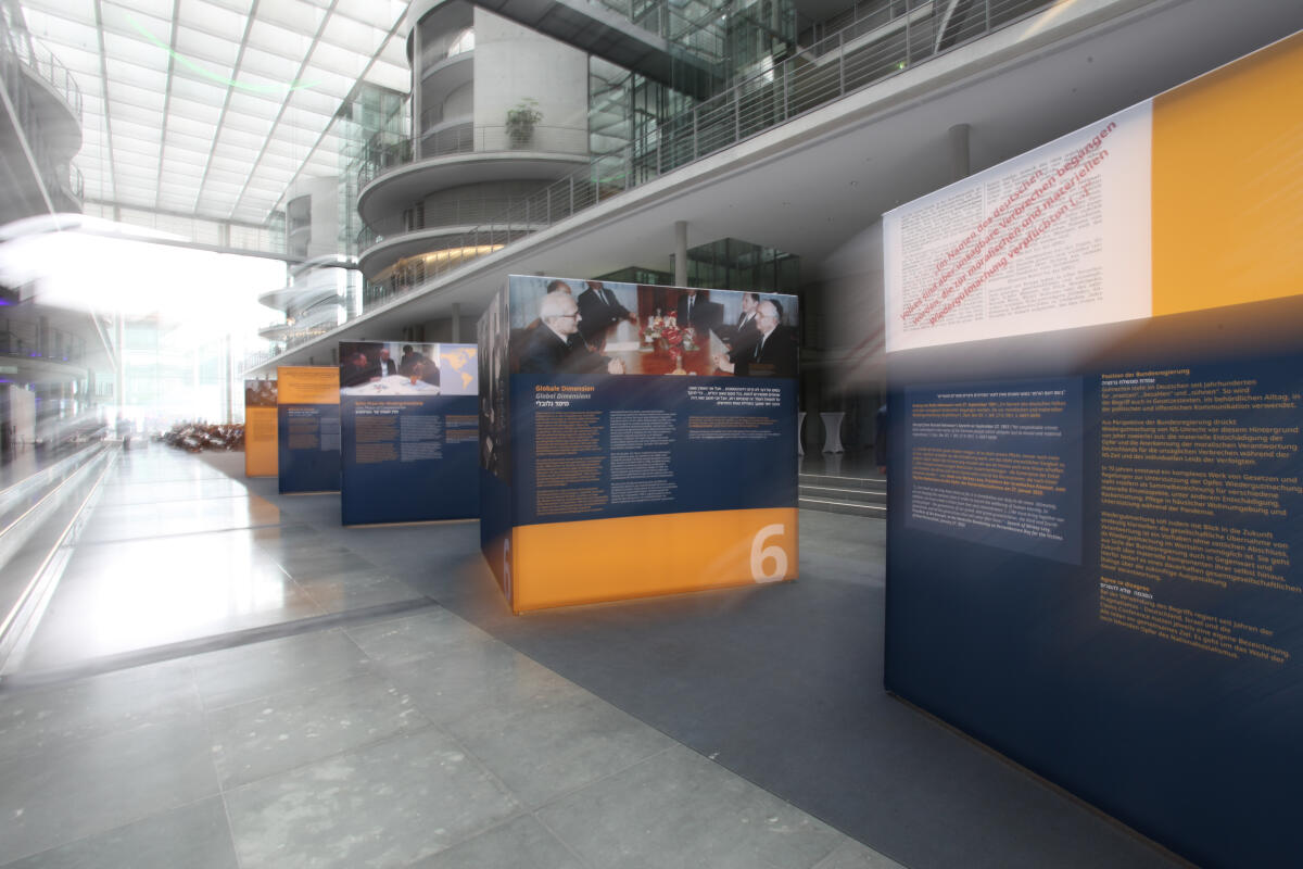  Dokumentation der Ausstellung anlässlich 70 Jahre Luxemburger Abkommen zur Wiedergutmachung nationalsozialistischen Unrechts. Blick auf die Ausstellungsexponate in der Halle des Paul-Läbe-Hauses.; Das von der Bundesrepublik Deutschland, dem Staat Israel und der Jewish Claims Conference 1952 geschlossene Übereinkommen bildet die Grundlage für die Entschädigung jüdischer Opfer nationalsozialistischer Verfolgung durch die Bundesrepublik Deutschland.; Die Ausstellung „70 Jahre Luxemburger Abkommen“ kann vom 6. September 2022 bis zum 5. Oktober 2022 im Paul-Löbe-Haus nach vorheriger Anmeldung besichtigt werden.; 