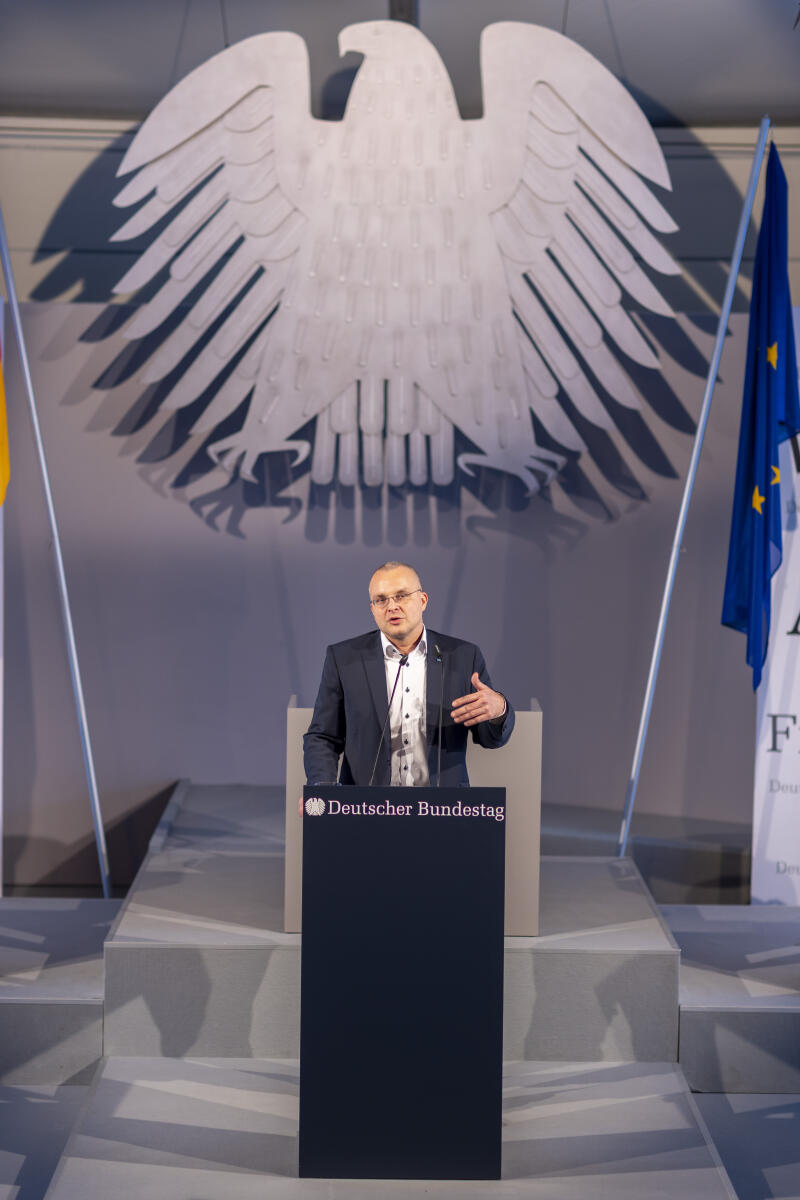 Anlässlich der Feierlichkeiten zum Tag der Deutschen Einheit präsentiert sich der Deutsche Bundestag vom 1. bis 3. Oktober 2022 auf dem Domplatz in Erfurt. Der Deutsche Bundestag bietet seinen Gästen ein abwechslungsreiches und unterhaltsames Programm. Wissenswertes über das Parlament erfahren die Gäste im „Kommunikationsforum“. Es werden verschiedene Informationsmaterialien rund ums Parlament ausgegeben und multimediale Angebote und Spiele für alle Altersgruppen zur Verfügung stehen. ; Hier der Abgeordnete Marcus Bühl, AfD, MdB, bei einem Rollenspiel im Forum Plenarsitzung. Bühl, Marcus Anlässlich der Feierlichkeiten zum Tag der Deutschen Einheit präsentiert sich der Deutsche Bundestag vom 1. bis 3. Oktober 2022 auf dem Domplatz in Erfurt. Der Deutsche Bundestag bietet seinen Gästen ein abwechslungsreiches und unterhaltsames Programm. Wissenswertes über das Parlament erfahren die Gäste im „Kommunikationsforum“. Es werden verschiedene Informationsmaterialien rund ums Parlament ausgegeben und multimediale Angebote und Spiele für alle Altersgruppen zur Verfügung stehen. ; Hier der Abgeordnete Marcus Bühl, AfD, MdB, bei einem Rollenspiel im Forum Plenarsitzung.