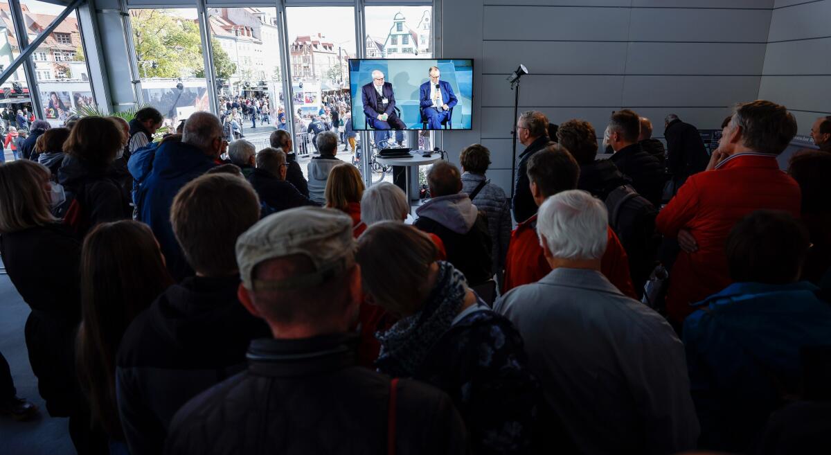 Anlässlich der Feierlichkeiten zum Tag der Deutschen Einheit präsentiert sich der Deutsche Bundestag vom 1. bis 3. Oktober 2022 auf dem Domplatz in Erfurt. Der Deutsche Bundestag bietet seinen Gästen ein abwechslungsreiches und unterhaltsames Programm. Wissenswertes über das Parlament erfahren die Gäste im „Kommunikationsforum“. Es werden verschiedene Informationsmaterialien rund ums Parlament ausgegeben und multimediale Angebote und Spiele für alle Altersgruppen zur Verfügung stehen. ; Hier sehen sich Gäste im Kommunikationsforum des Deutschen Bundestages die Live-Übertragung vom Gespräch des Fraktionsvorsitzenden Friedrich Merz, CDU/CSU, MdB, im Forum Plenarsaal an. Merz, Friedrich Anlässlich der Feierlichkeiten zum Tag der Deutschen Einheit präsentiert sich der Deutsche Bundestag vom 1. bis 3. Oktober 2022 auf dem Domplatz in Erfurt. Der Deutsche Bundestag bietet seinen Gästen ein abwechslungsreiches und unterhaltsames Programm. Wissenswertes über das Parlament erfahren die Gäste im „Kommunikationsforum“. Es werden verschiedene Informationsmaterialien rund ums Parlament ausgegeben und multimediale Angebote und Spiele für alle Altersgruppen zur Verfügung stehen. ; Hier sehen sich Gäste im Kommunikationsforum des Deutschen Bundestages die Live-Übertragung vom Gespräch des Fraktionsvorsitzenden Friedrich Merz, CDU/CSU, MdB, im Forum Plenarsaal an.