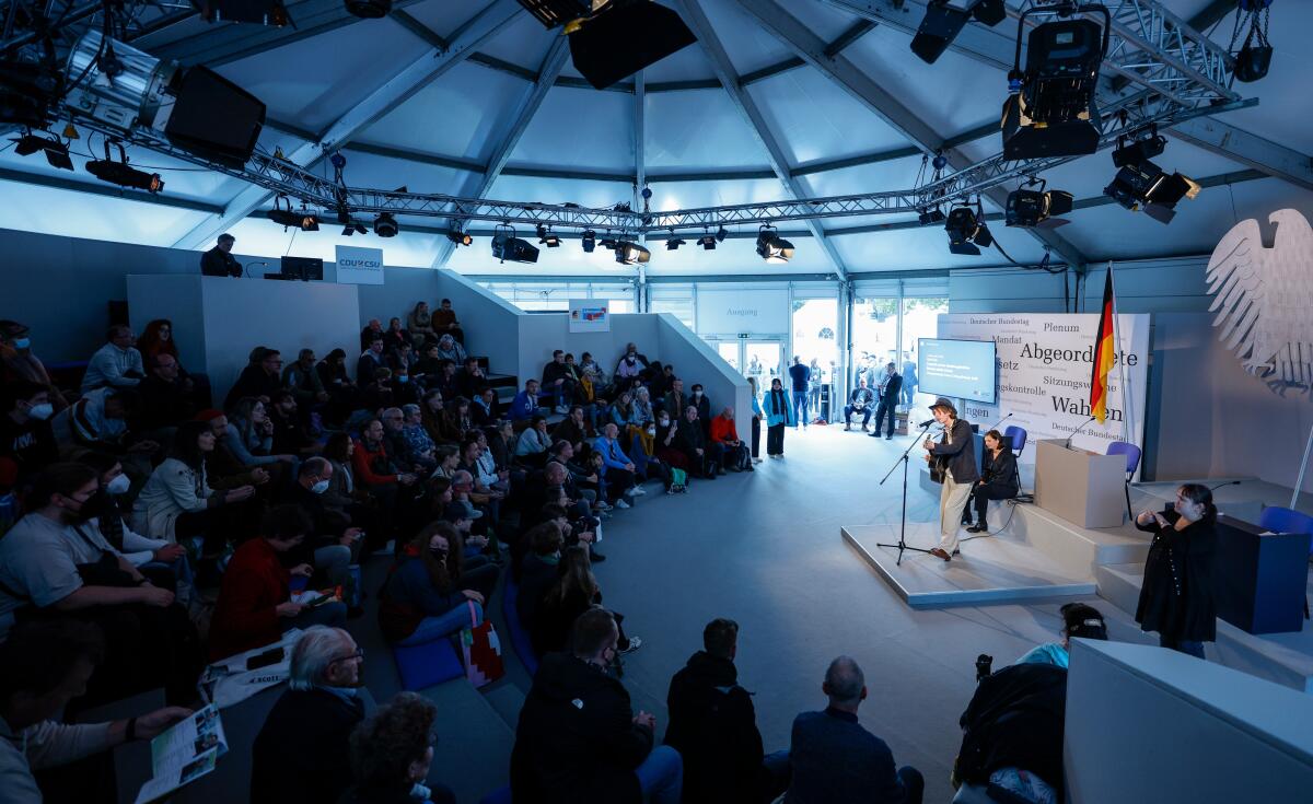 Anlässlich der Feierlichkeiten zum Tag der Deutschen Einheit präsentiert sich der Deutsche Bundestag vom 1. bis 3. Oktober 2022 auf dem Domplatz in Erfurt. Der Deutsche Bundestag bietet seinen Gästen ein abwechslungsreiches und unterhaltsames Programm. Wissenswertes über das Parlament erfahren die Gäste im „Kommunikationsforum“. Es werden verschiedene Informationsmaterialien rund ums Parlament ausgegeben und multimediale Angebote und Spiele für alle Altersgruppen zur Verfügung stehen. ; Hier im Gespräch Bundestagsvizepräsidentin Katrin Göring-Eckardt, Bündnis 90/Die Grünen, MdB, (links), und Max Prosa, Musiker, Lyriker und Theaterautor, (rechts), im Forum Plenarsaal. Göring-Eckardt, Katrin; Prosa, Max Anlässlich der Feierlichkeiten zum Tag der Deutschen Einheit präsentiert sich der Deutsche Bundestag vom 1. bis 3. Oktober 2022 auf dem Domplatz in Erfurt. Der Deutsche Bundestag bietet seinen Gästen ein abwechslungsreiches und unterhaltsames Programm. Wissenswertes über das Parlament erfahren die Gäste im „Kommunikationsforum“. Es werden verschiedene Informationsmaterialien rund ums Parlament ausgegeben und multimediale Angebote und Spiele für alle Altersgruppen zur Verfügung stehen. ; Hier im Gespräch Bundestagsvizepräsidentin Katrin Göring-Eckardt, Bündnis 90/Die Grünen, MdB, (links), und Max Prosa, Musiker, Lyriker und Theaterautor, (rechts), im Forum Plenarsaal.