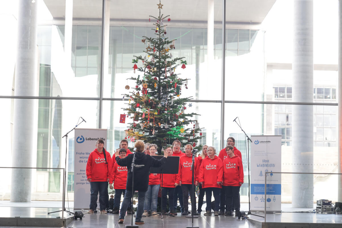 Bundestagspräsidentin Bärbel Bas, SPD, MdB, nimmt einen Weihnachtsbaum der Bundesvereinigung Lebenshilfe e.V. entgegen. Hier der Chor „Die Notenträumer“ der Lebenshilfe Hildesheim vor dem Weihnachtsbaum. Bundestagspräsidentin Bärbel Bas, SPD, MdB, nimmt einen Weihnachtsbaum der Bundesvereinigung Lebenshilfe e.V. entgegen. Hier der Chor „Die Notenträumer“ der Lebenshilfe Hildesheim vor dem Weihnachtsbaum.