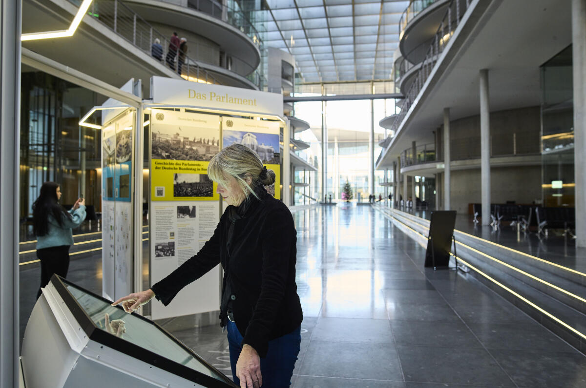  Besucherinnen und Besucher sehen sich die Wanderausstellung des Deutschen Bundestages, hier den Multitouch-Tisch mit interaktiven Angeboten, in der Halle des Paul-Löbe-Hauses an. 