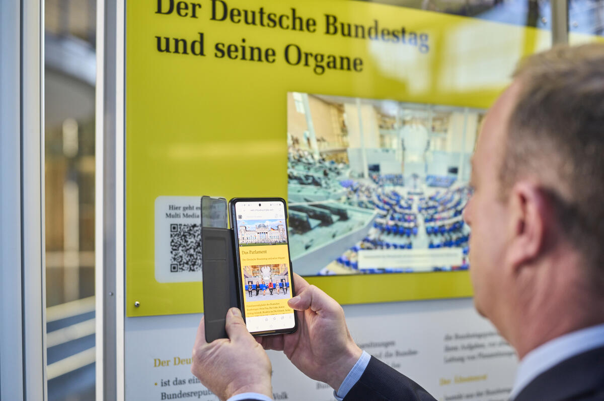 Wanderausstellung des Deutschen Bundestages in der Halle des Paul-Löbe-Hauses. Ein Besucher scannt mit einem Mobiltelefon einen QR-Code, um sich weitere interaktive Inhalte der Ausstellung im begleitenden Multimedia-Guide anzusehen. Wanderausstellung des Deutschen Bundestages in der Halle des Paul-Löbe-Hauses. Ein Besucher scannt mit einem Mobiltelefon einen QR-Code, um sich weitere interaktive Inhalte der Ausstellung im begleitenden Multimedia-Guide anzusehen.