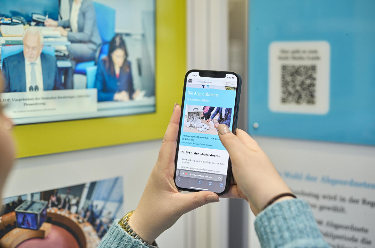  Wanderausstellung des Deutschen Bundestages in der Halle des Paul-Löbe-Hauses. Eine Besucherin scannt mit einem Mobiltelefon einen QR-Code, um sich weitere interaktive Inhalte der Ausstellung im begleitenden Multimedia-Guide anzusehen.