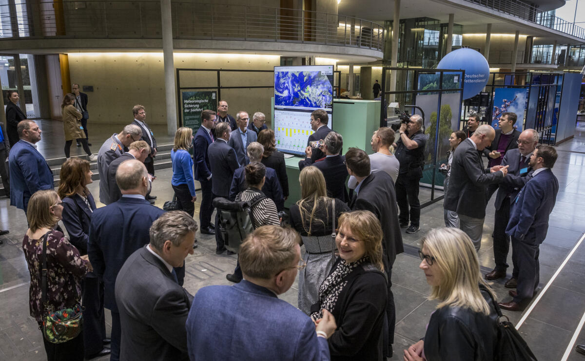  Besucherinnen und Besucher beim Rundgang durch die Ausstellung "70 Jahre zwischen Natur und Gesellschaft", die anlässlich des 70. Jubiläums des Deutschen Wetterdienstes in der Halle des Paul-Löbe-Hauses gezeigt wird, nach der Ausstellungseröffnung. 