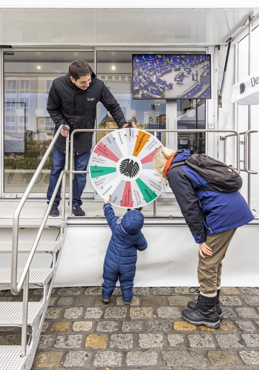  Infomobil des Deutschen Bundestages in Rostock. Ein junger Besucher spielt am Glücksrad.