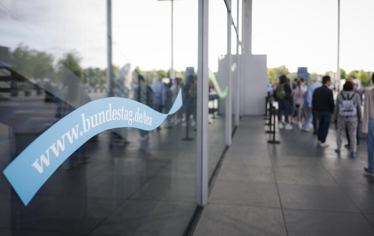 Bunte Banner an der Glasfassade des Paul-Löbe-Hauses weisen auf den Tag der Ein- und Ausblicke des Deutschen Bundestages am 3. September 2023 und die Internetseite www.bundestag.de hin. Daneben warten Besucherinnen und Besucher in einer Schlange vor dem Eingang auf Einlass Bunte Banner an der Glasfassade des Paul-Löbe-Hauses weisen auf den Tag der Ein- und Ausblicke des Deutschen Bundestages am 3. September 2023 und die Internetseite www.bundestag.de hin. Daneben warten Besucherinnen und Besucher in einer Schlange vor dem Eingang auf Einlass